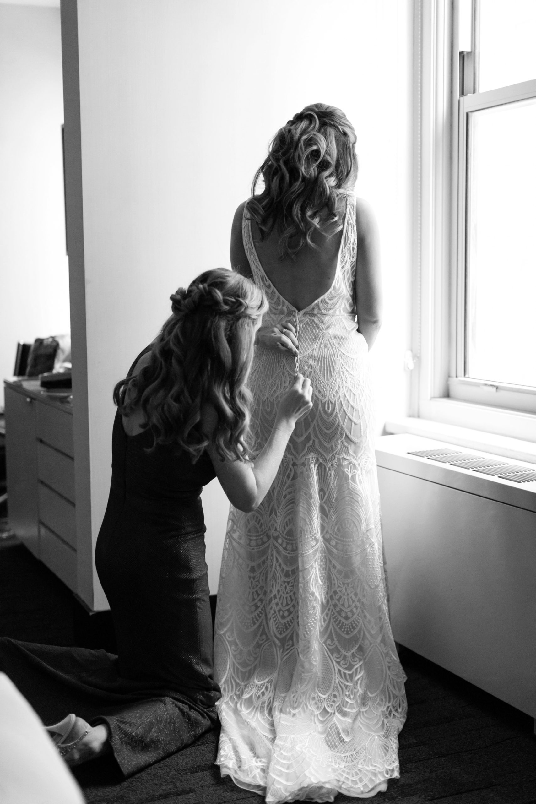 the bride got into her wedding dress with help from her maid of honor