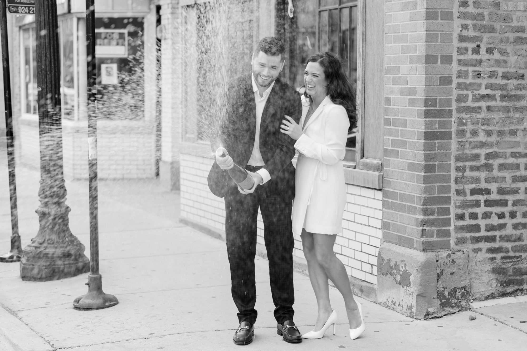 the couple spayed champagne during their Chicago engagement photos