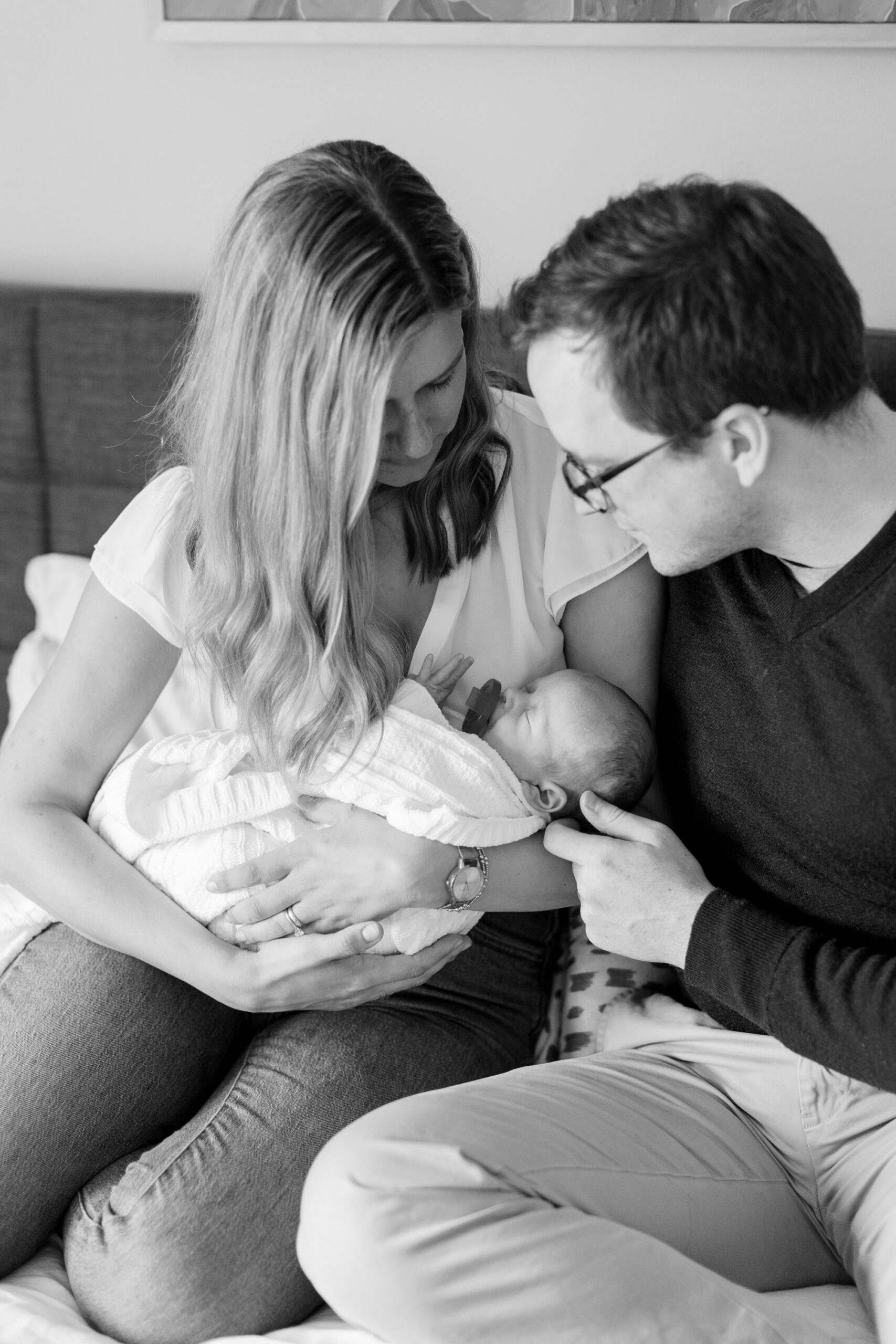 mom and dad look at baby during newborn photos