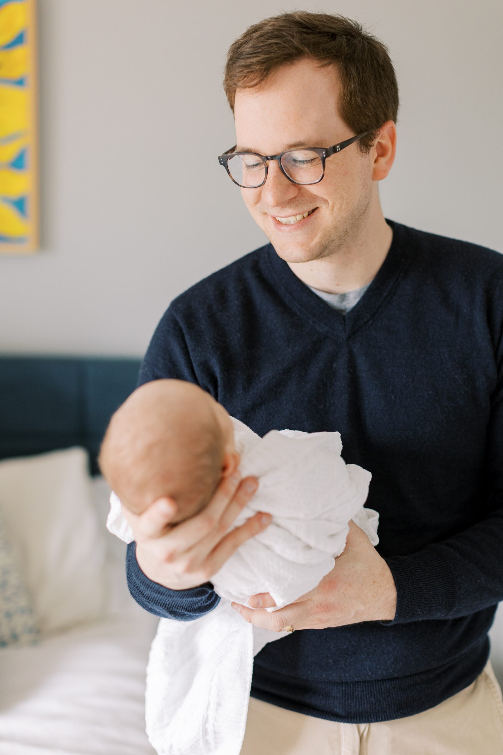 dad holds baby during newborn photo session at home
