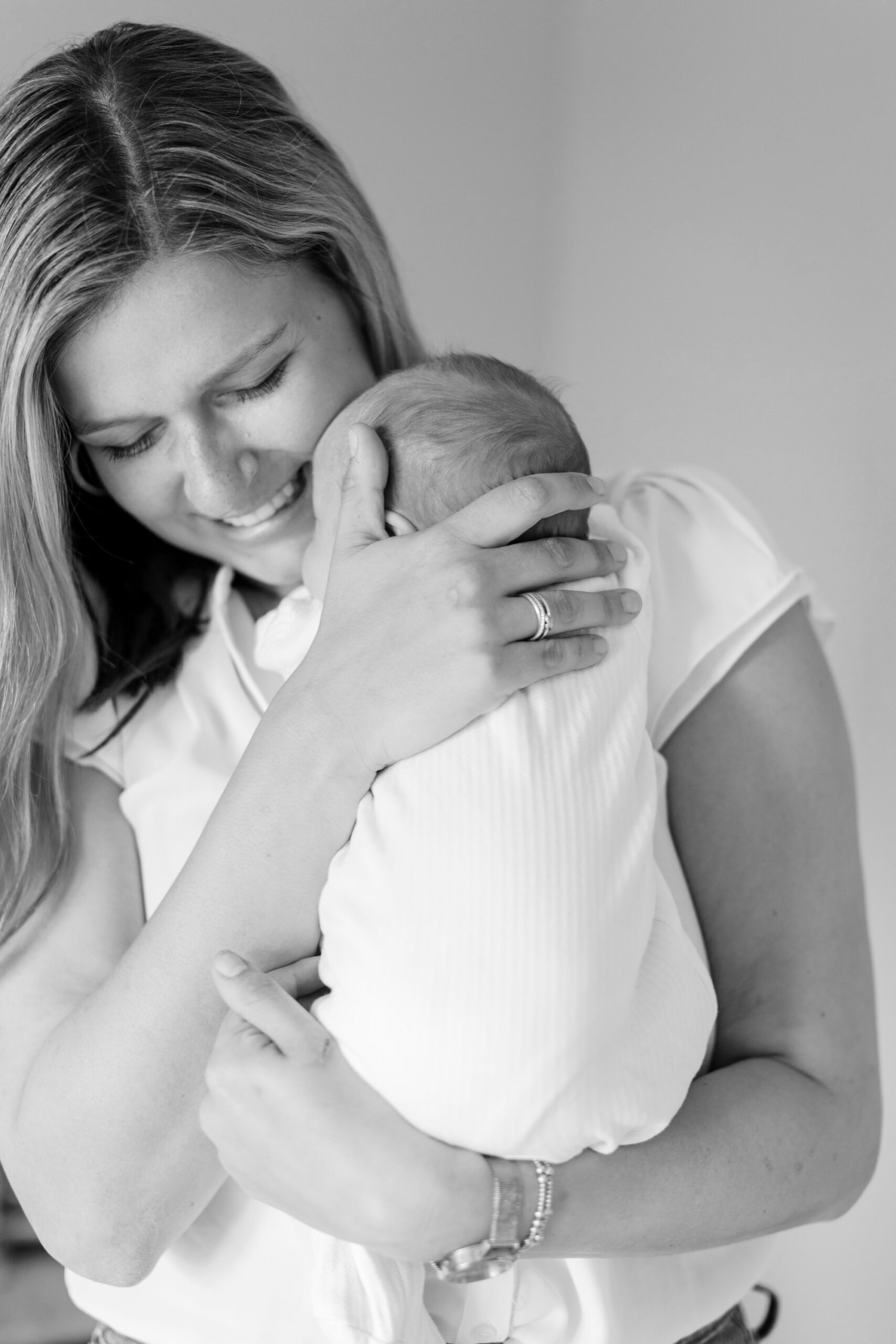 black and white photo of mom holding baby during home photoshoot