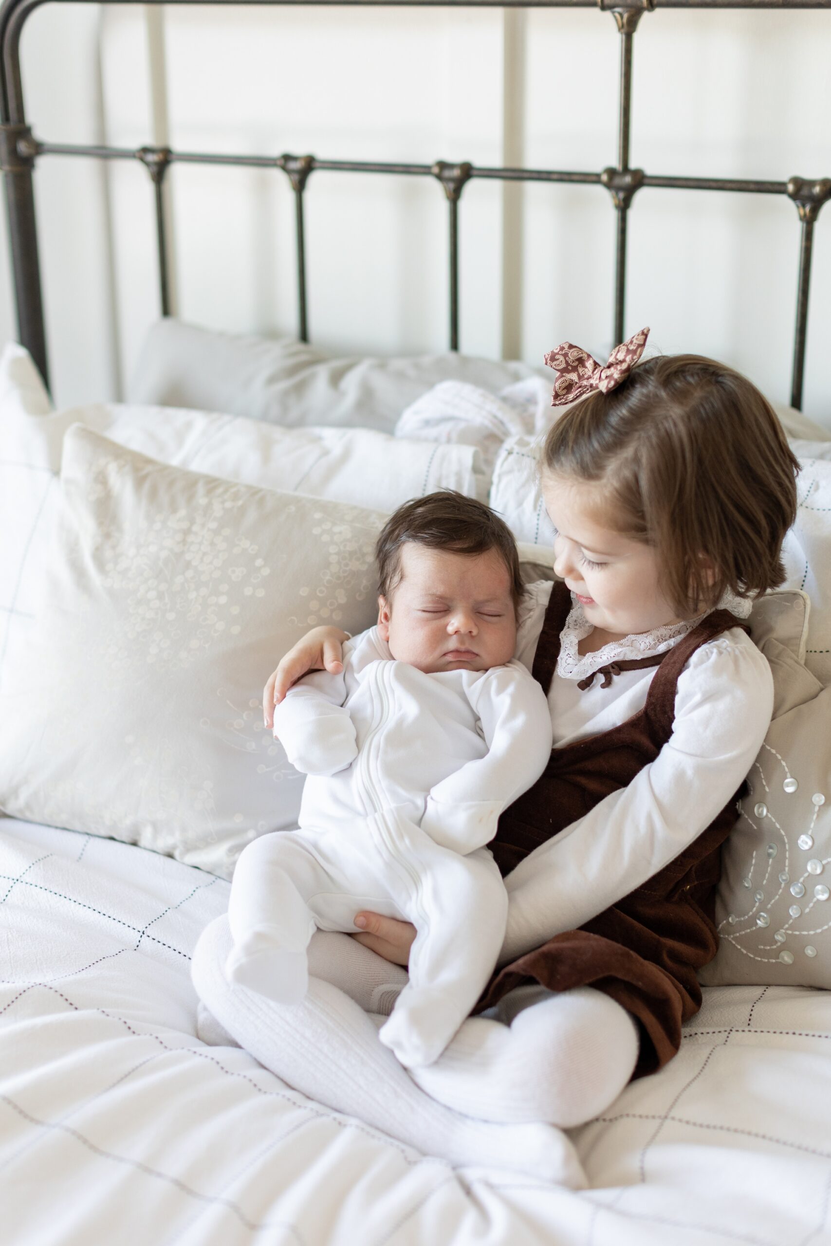 little girl holds her newborn brother