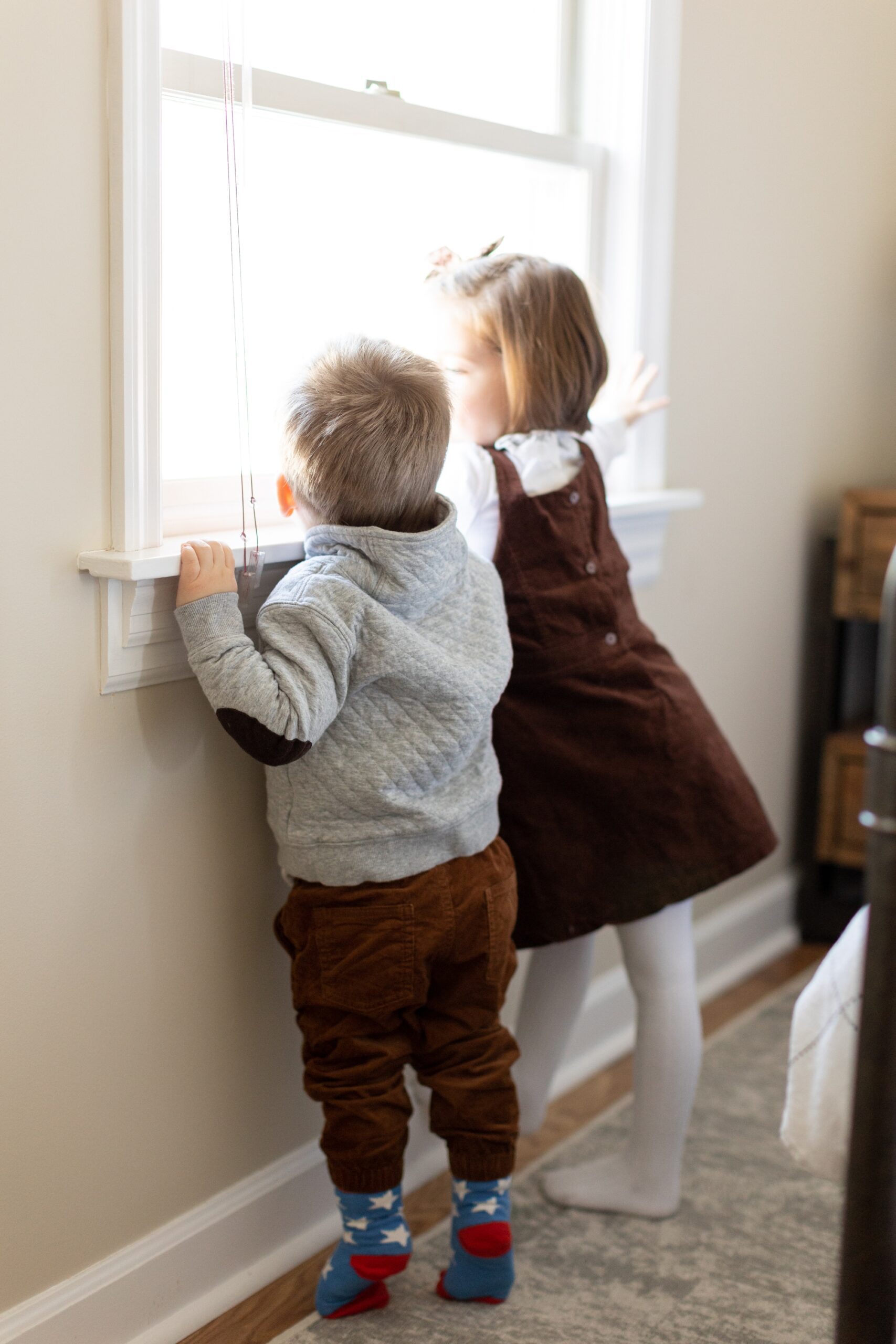 little children look out the window during family photos