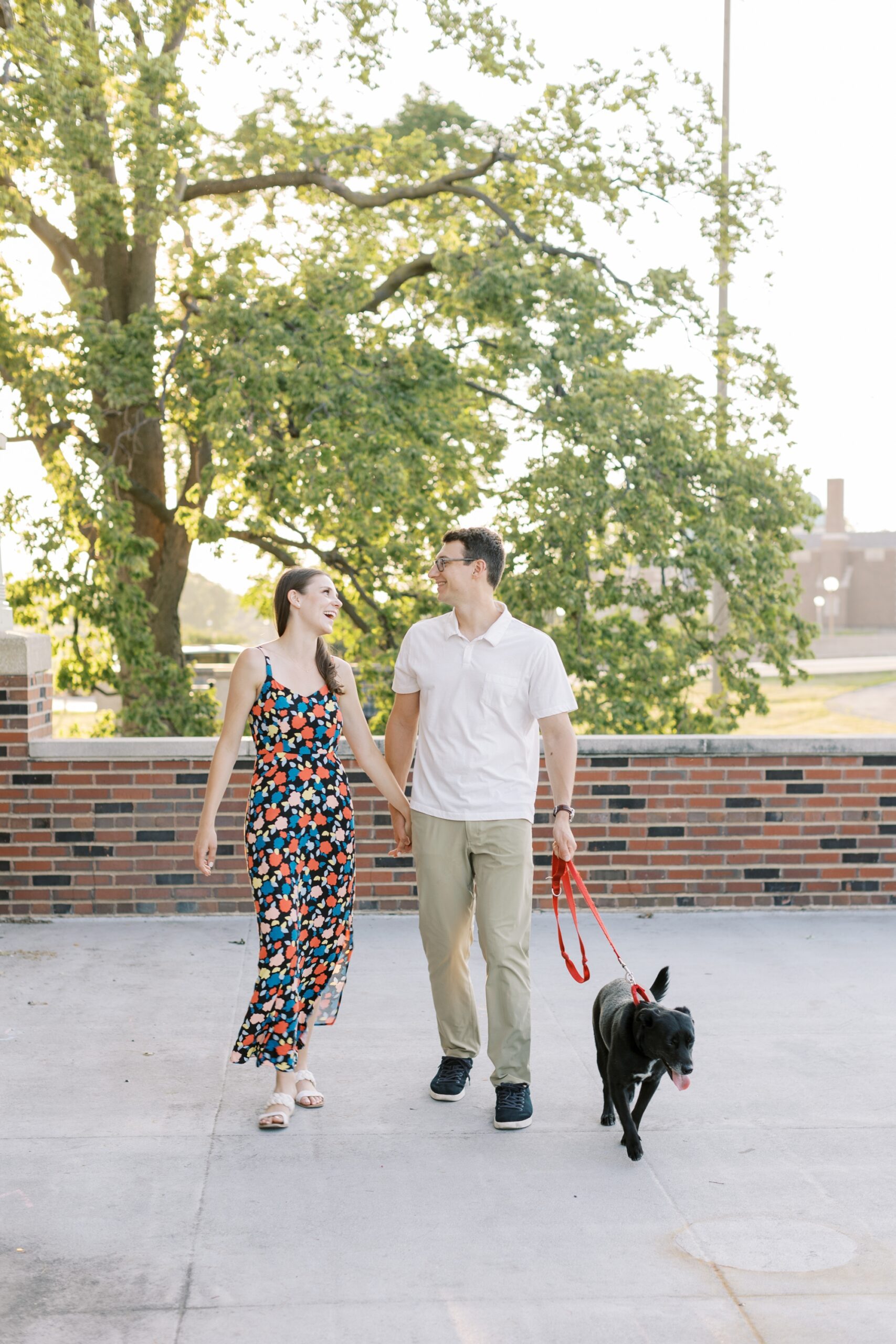 couple walks with dog during engagement photos