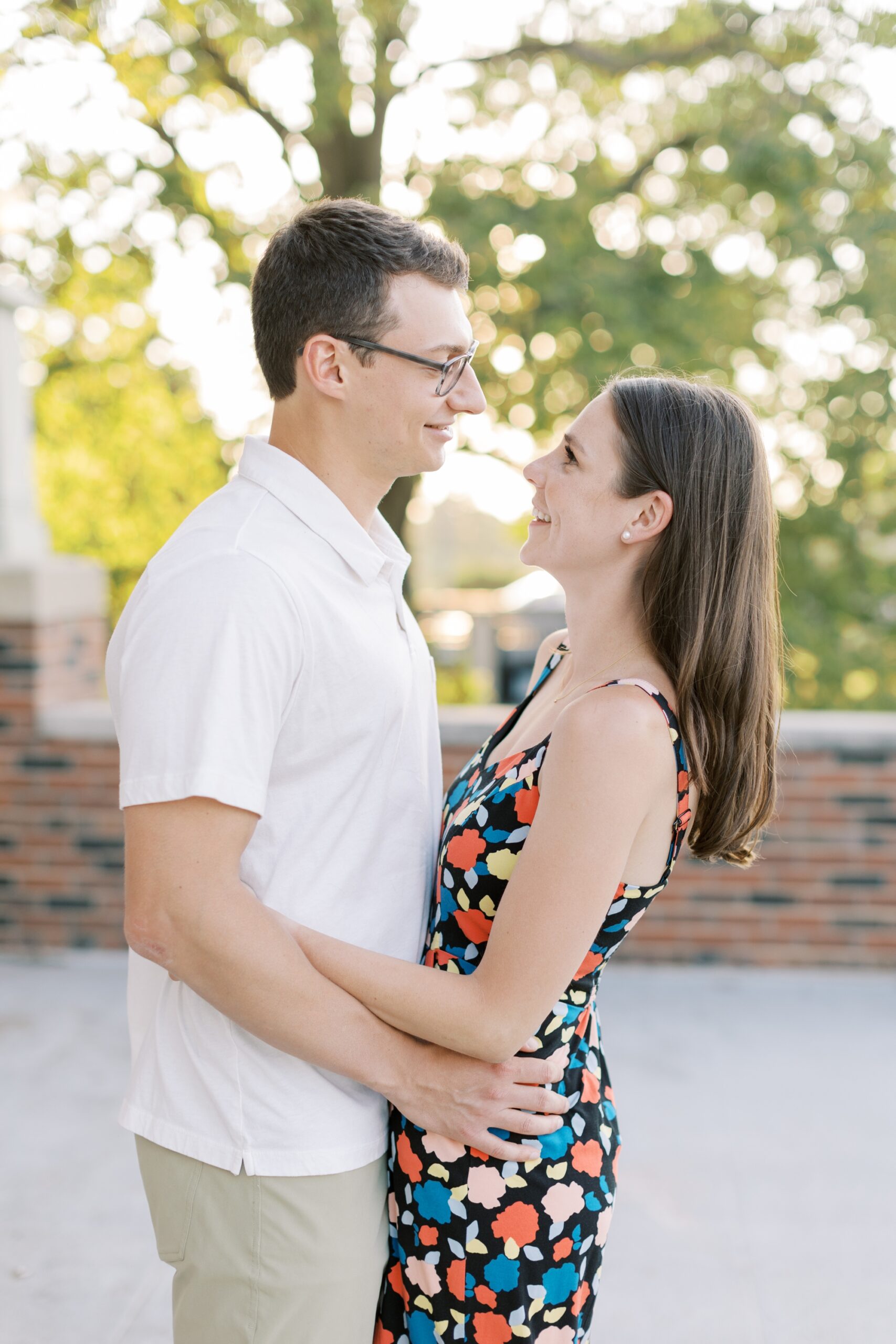 couple smiles at each other during engagement photoshoot