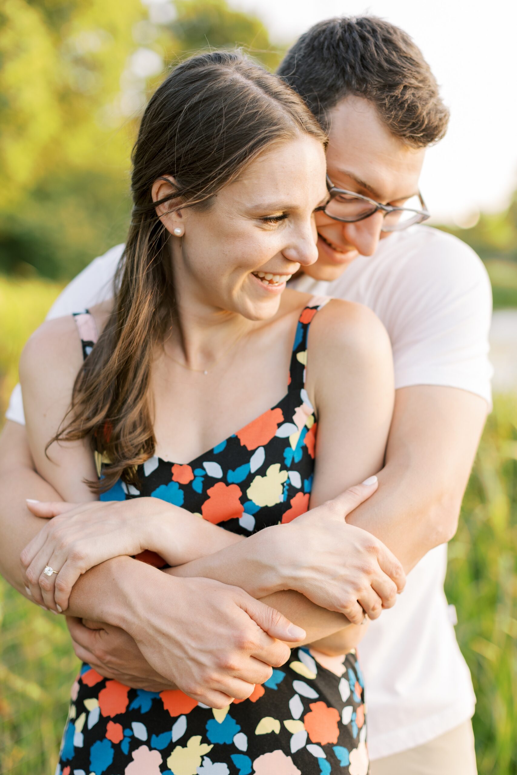 man hugs woman from behind during engagement photo session