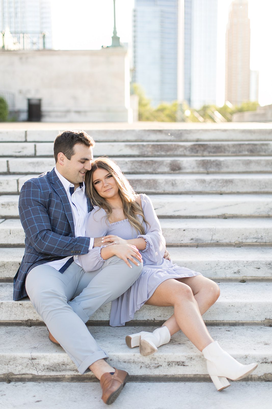 man and woman sit on stairs together during Chicago engagement photoshoot