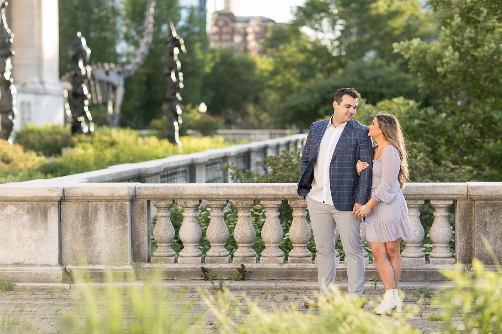man and woman smile at each other during outdoor engagement photos in Chicago