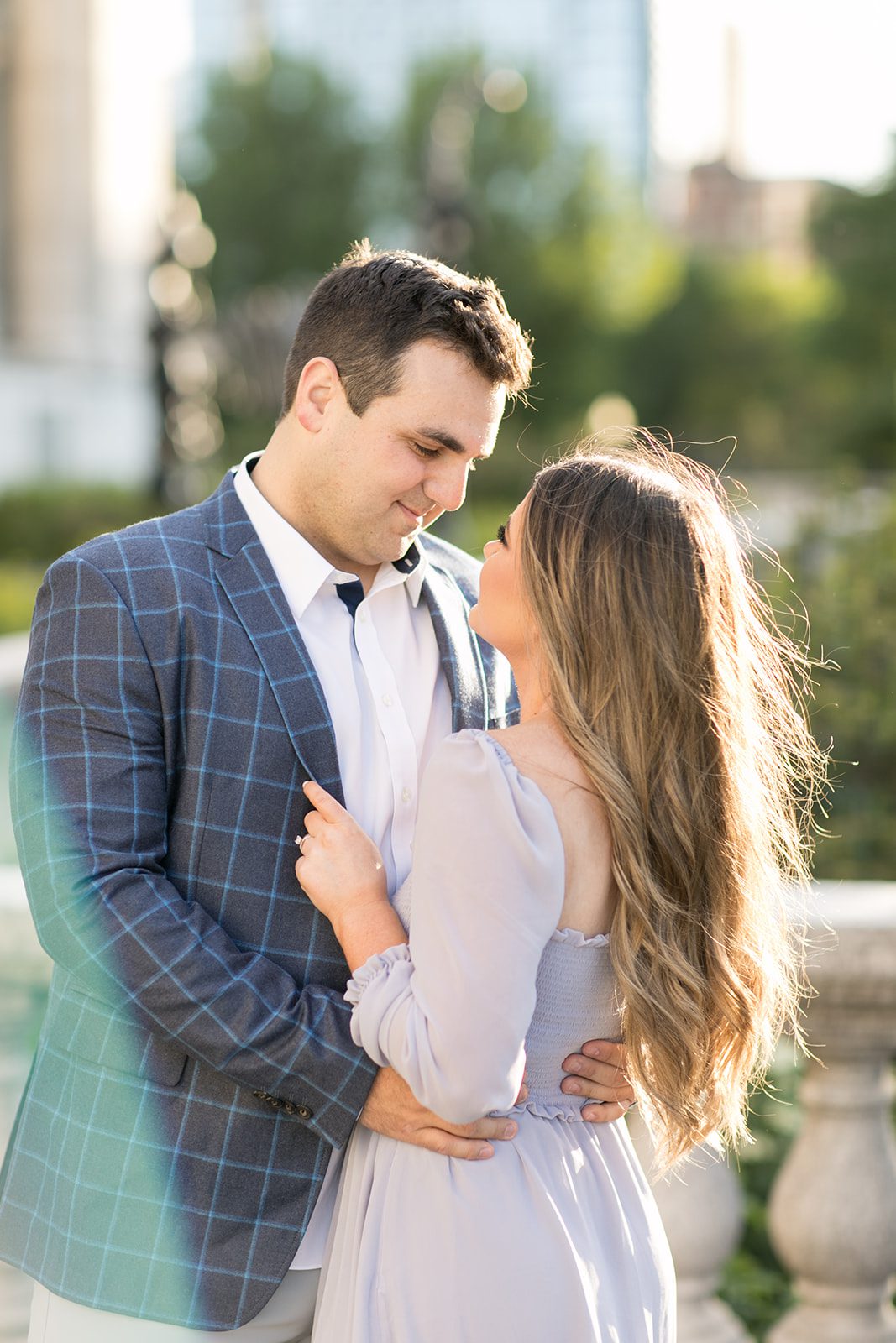 man and woman smile at each other during Chicago engagement photoshoot