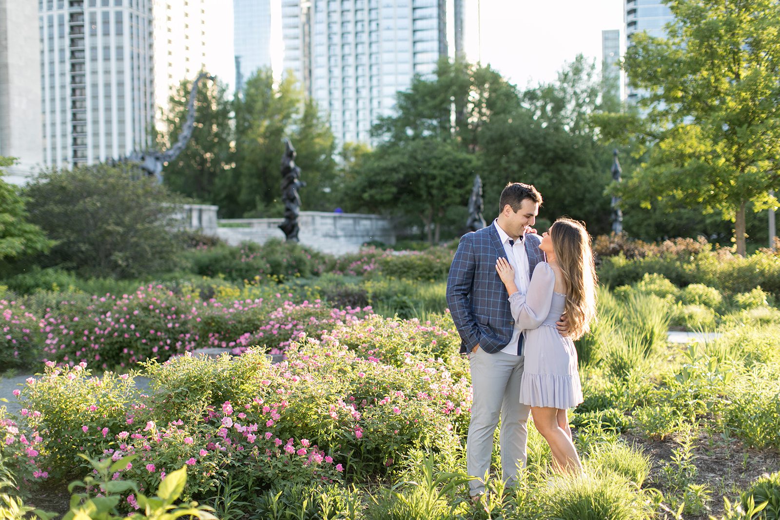 man and woman smile at each other during downtown Chicago engagement photoshoot
