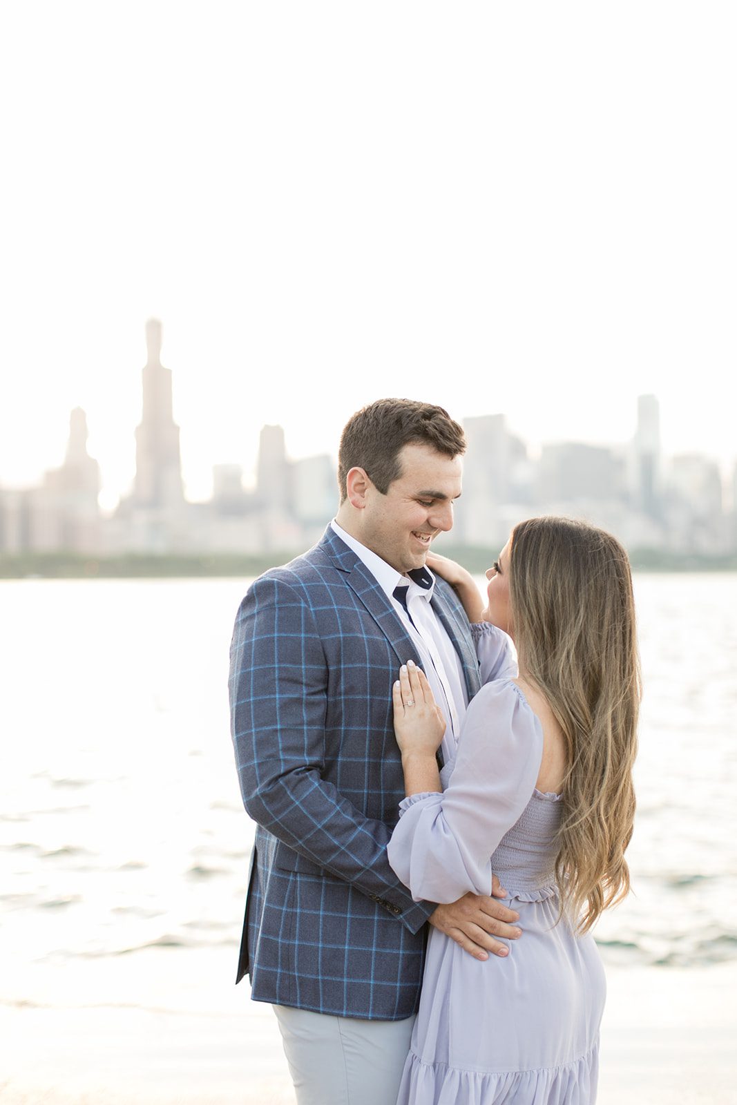 man and woman smile with the Chicago skyline behind them