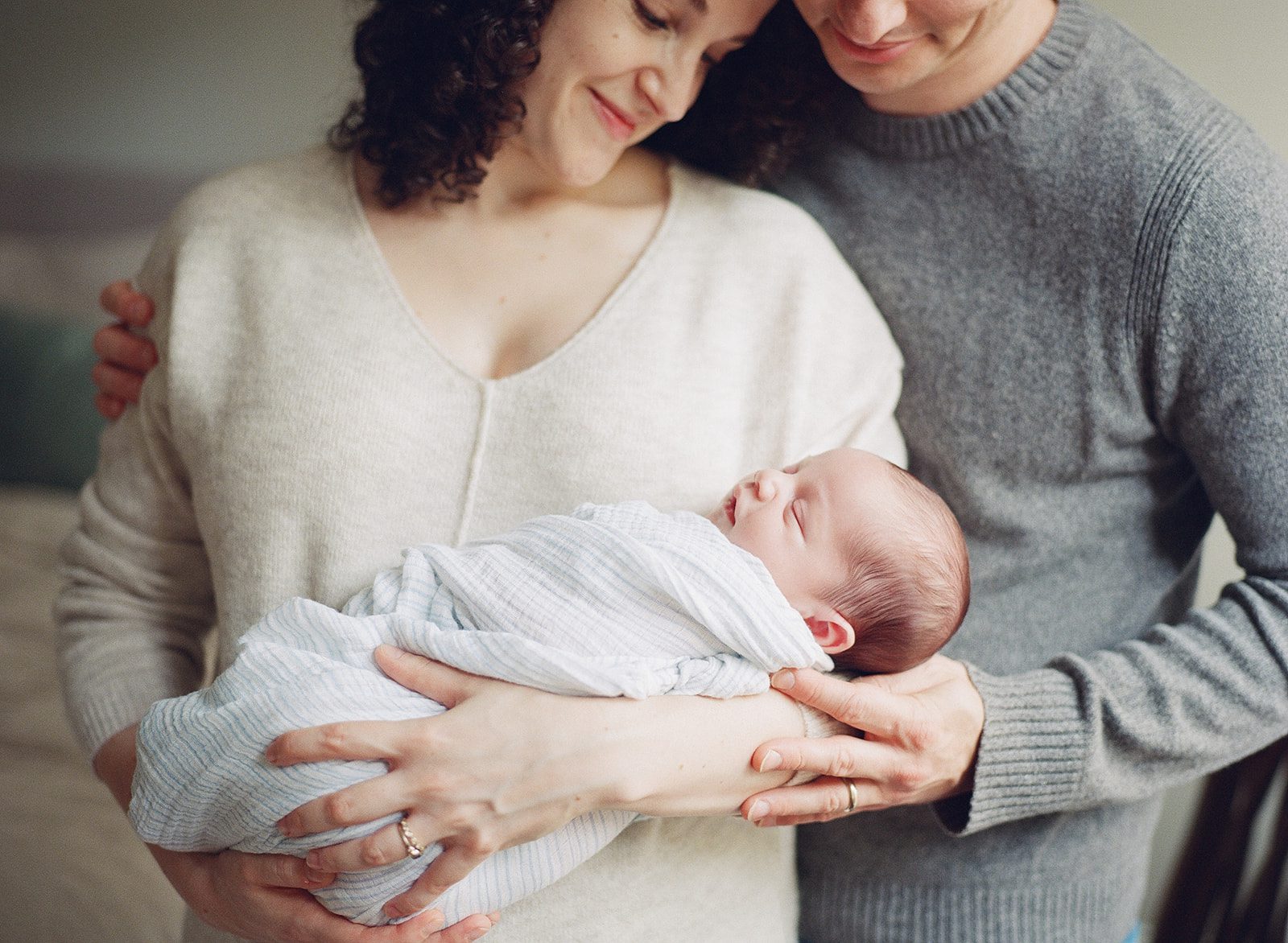man and woman hold newborn baby during chicago newborn photoshoot