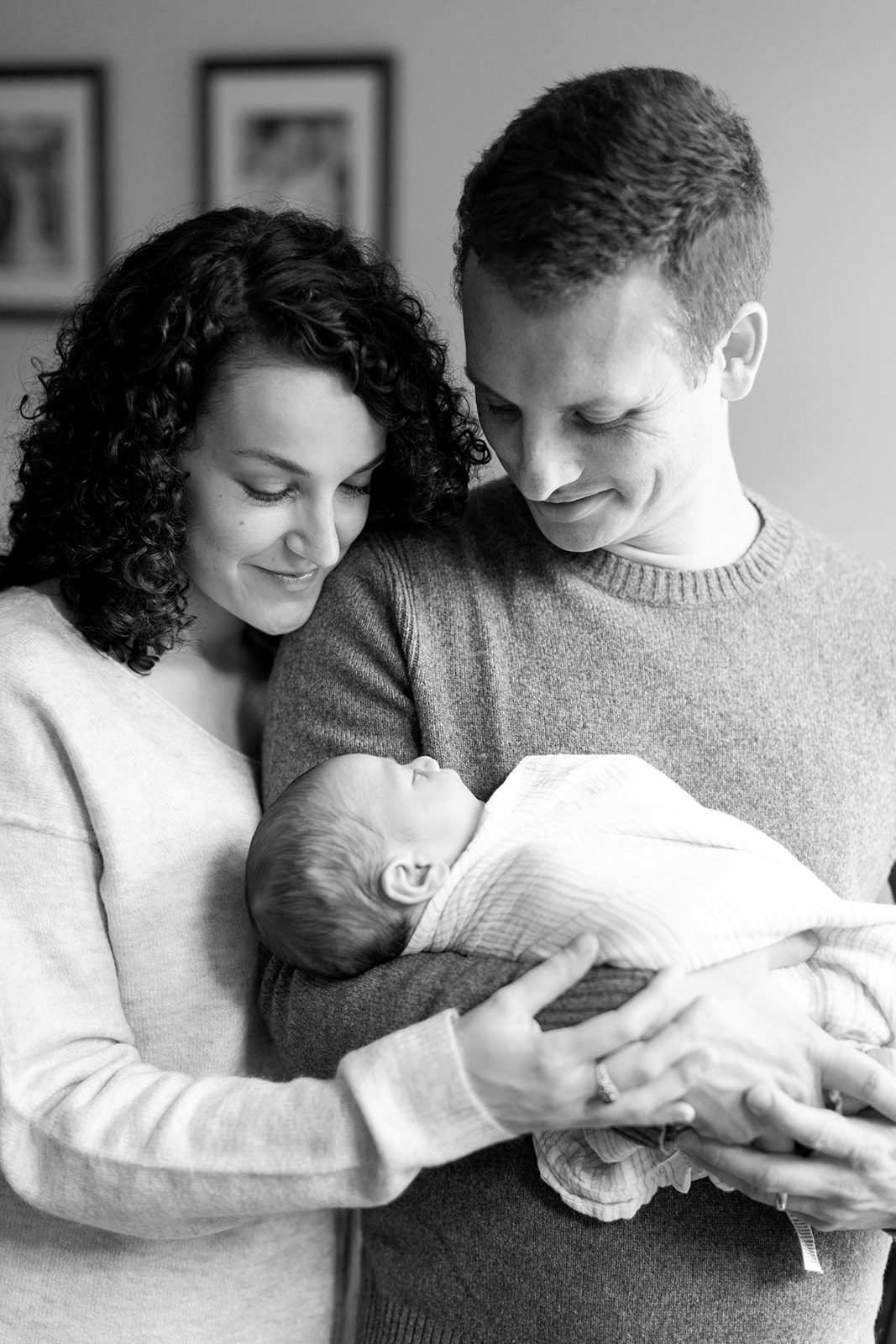 black and white photo of man and woman holding newborn baby