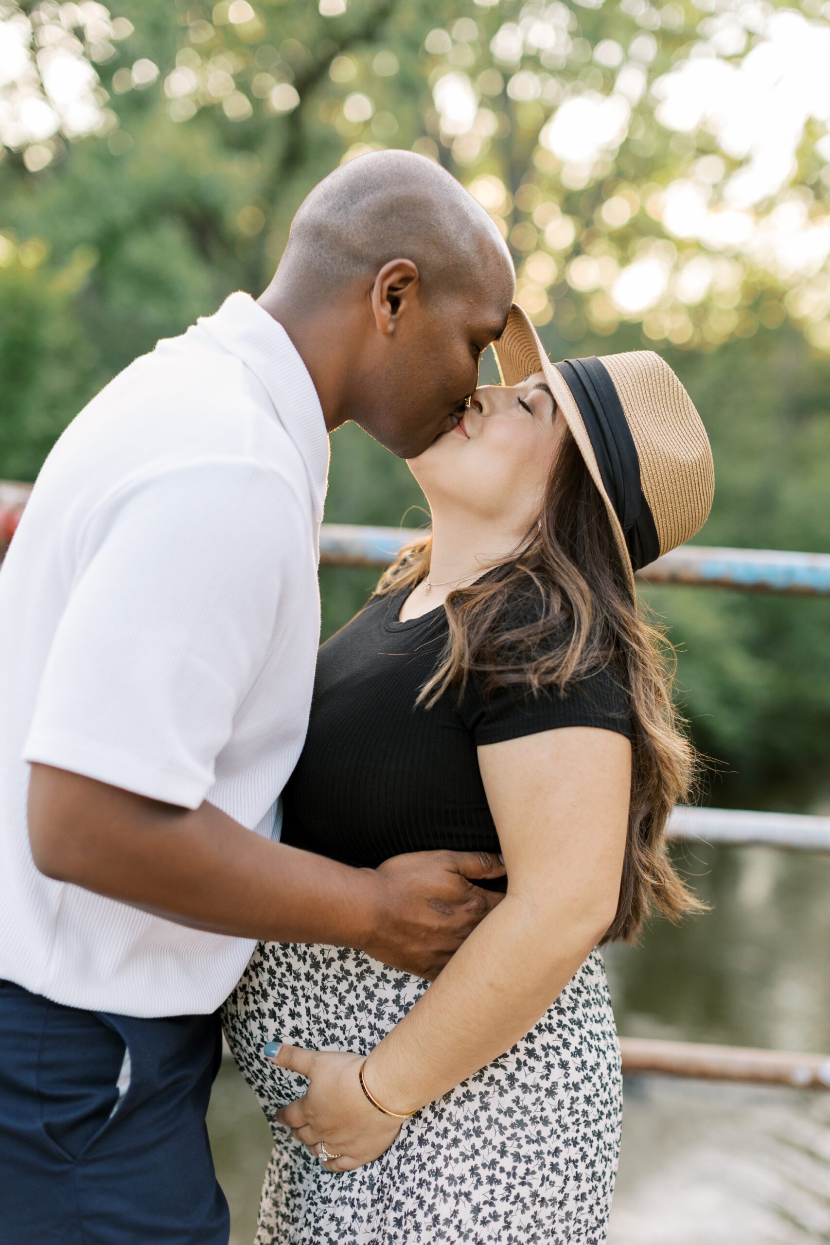 Man and woman kiss during Chicago summer outdoor maternity photos
