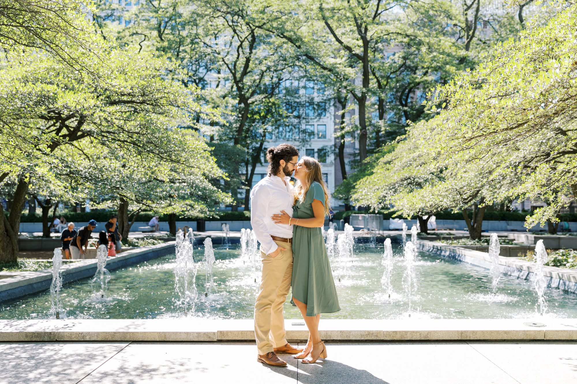 Man and woman kiss during their city engagement photoshoot