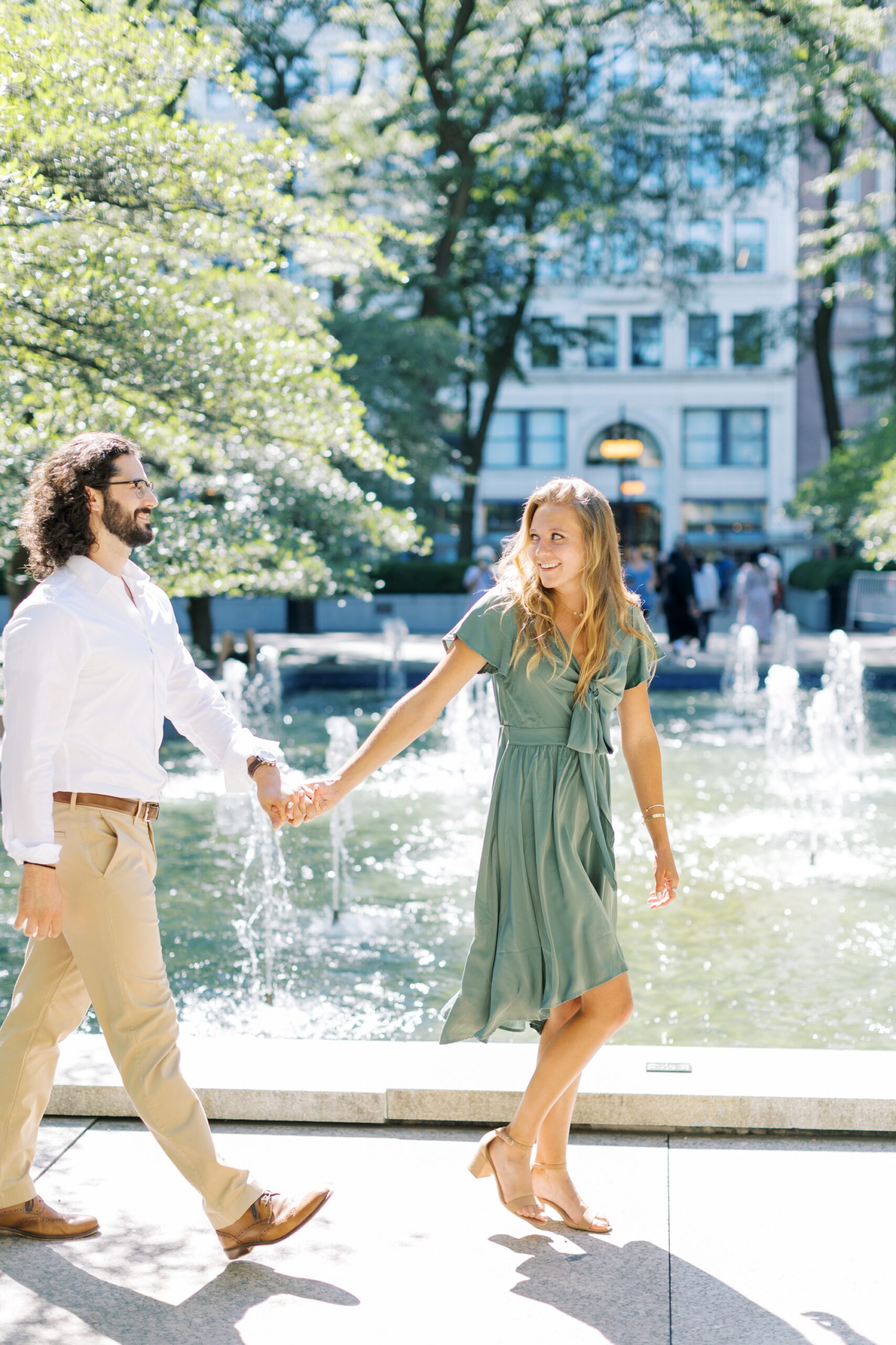 Man and woman hold hands during Downtown Chicago engagement photo session