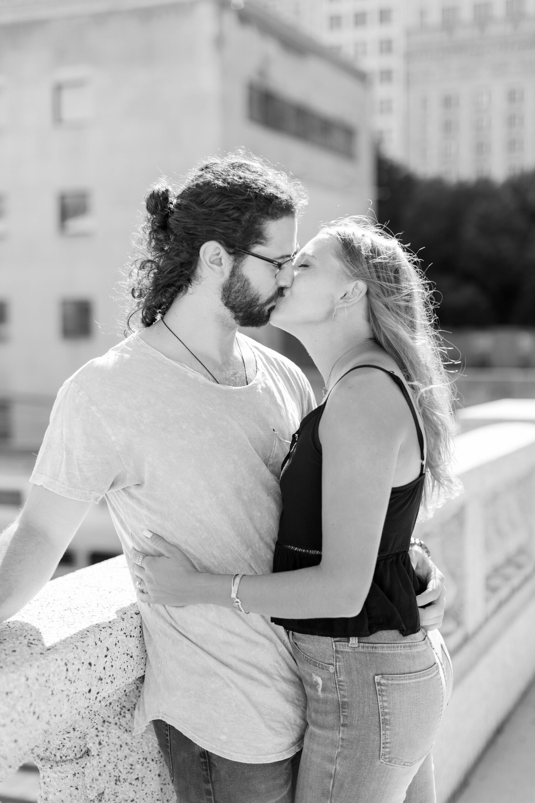 Man and woman kiss during casual engagement photoshoot in Chicago