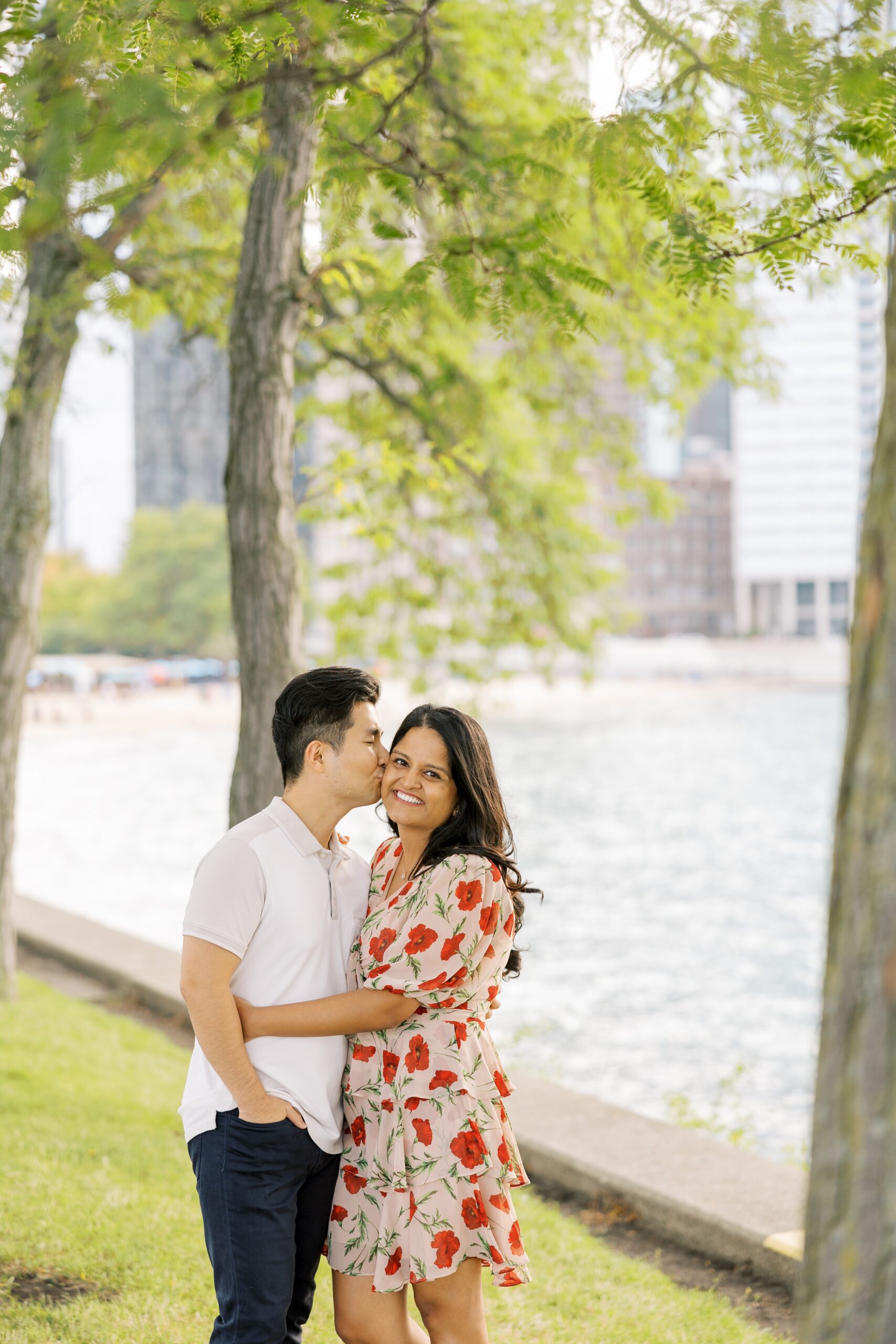 man kisses woman on the cheek during outdoor engagement session in chicago