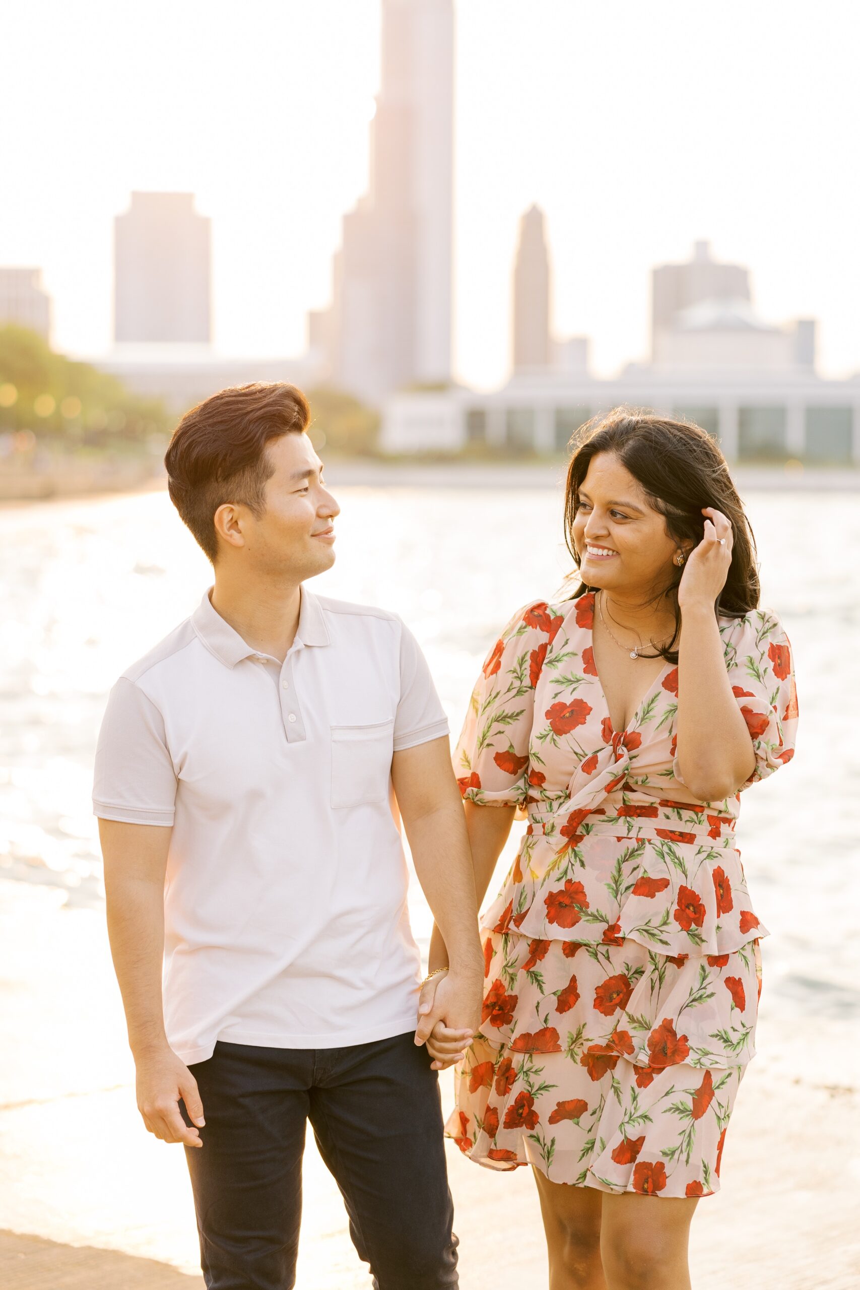 man and woman smile at each other during outdoor engagement photos in chicago