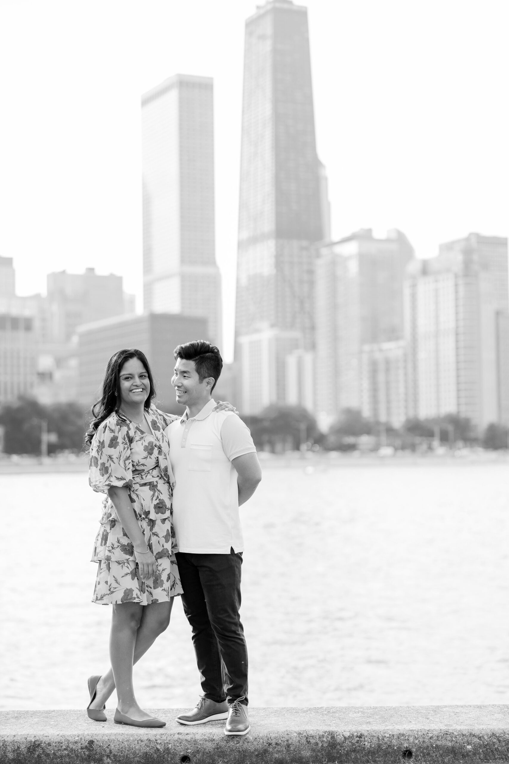 couple smiling with chicago skyline during outdoor engagement photos in chicago