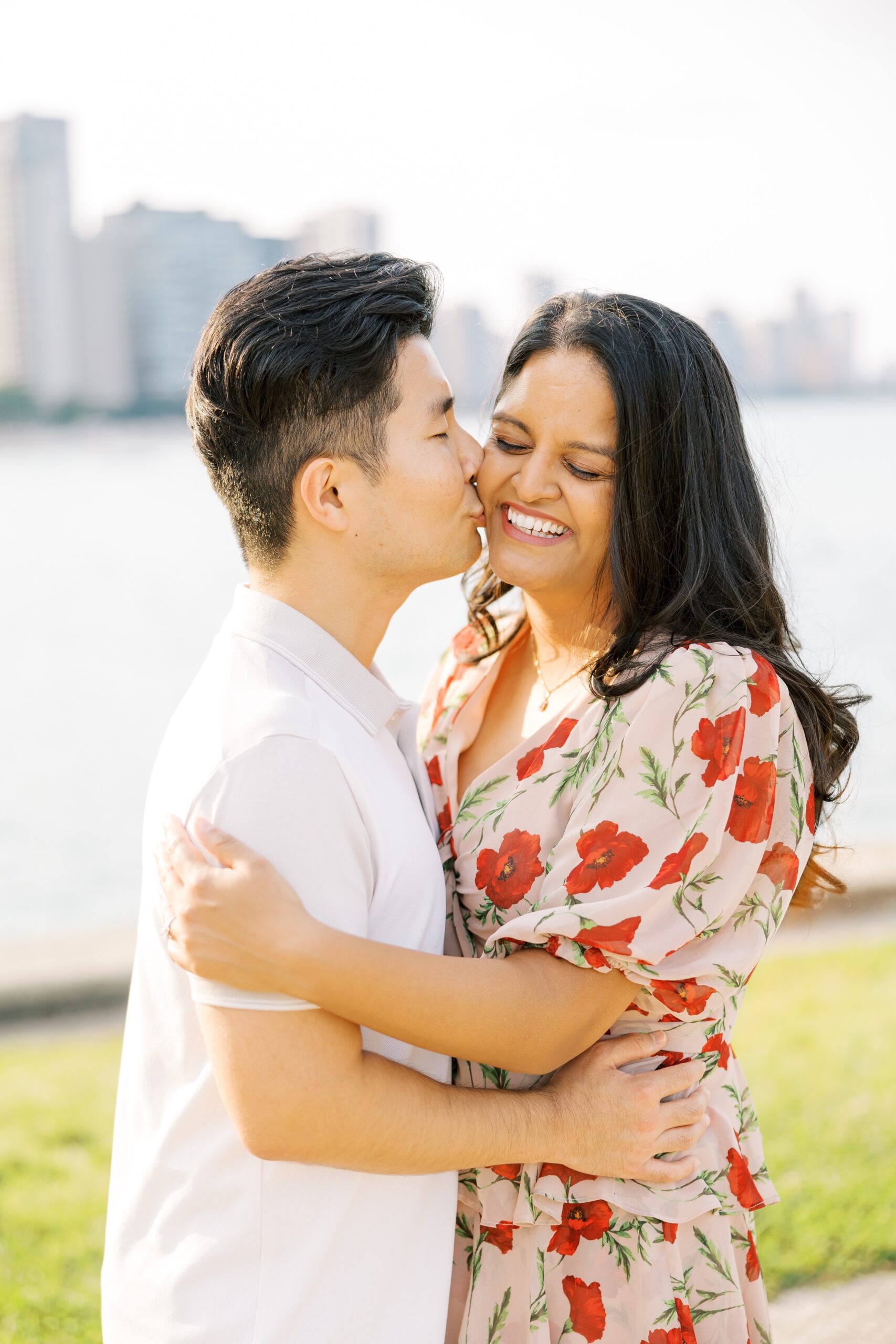 man kisses woman's cheek during outdoor engagement photos in Chicago