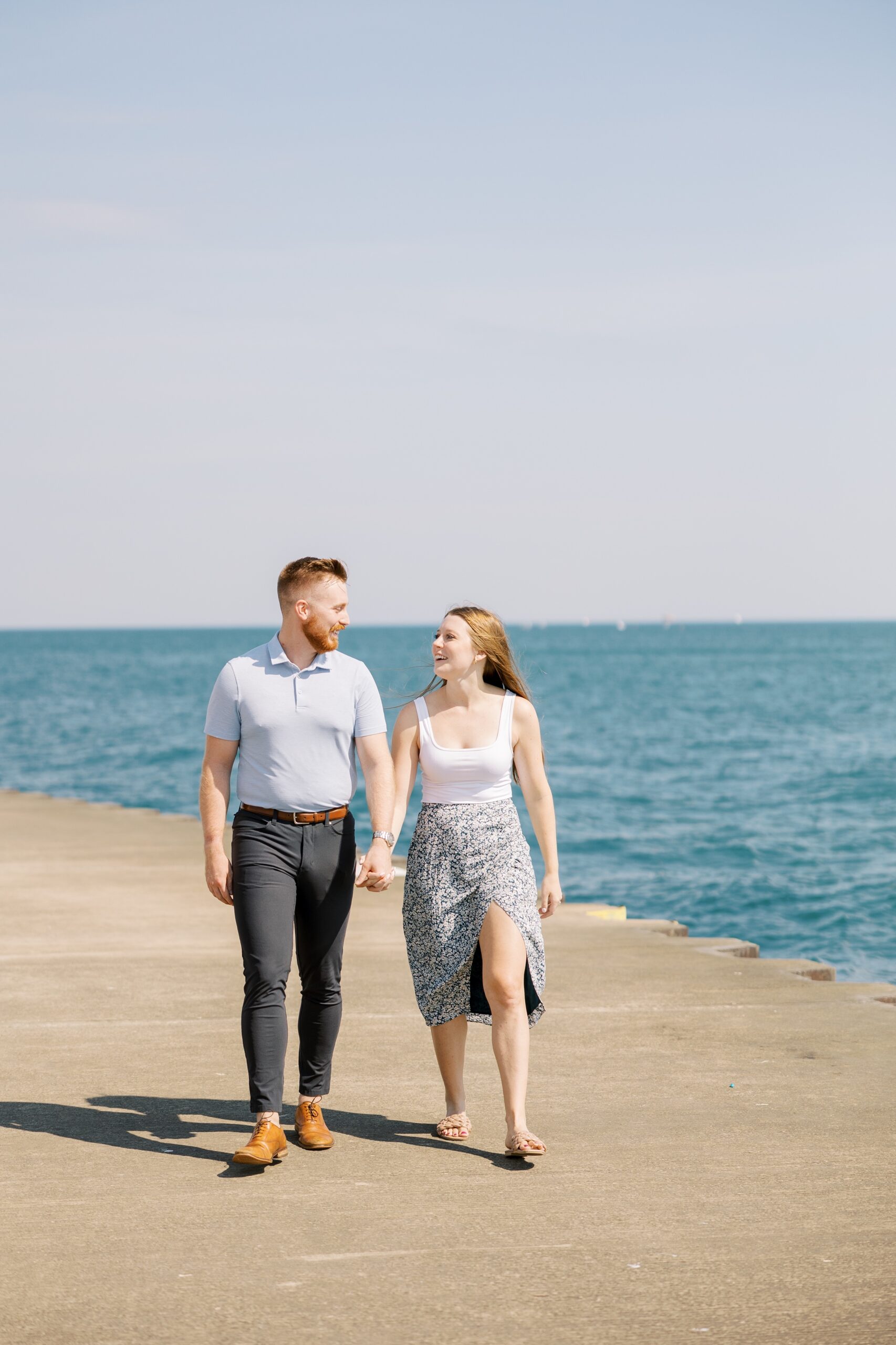 Man and woman walk along the Chicago lakefront after their proposal
