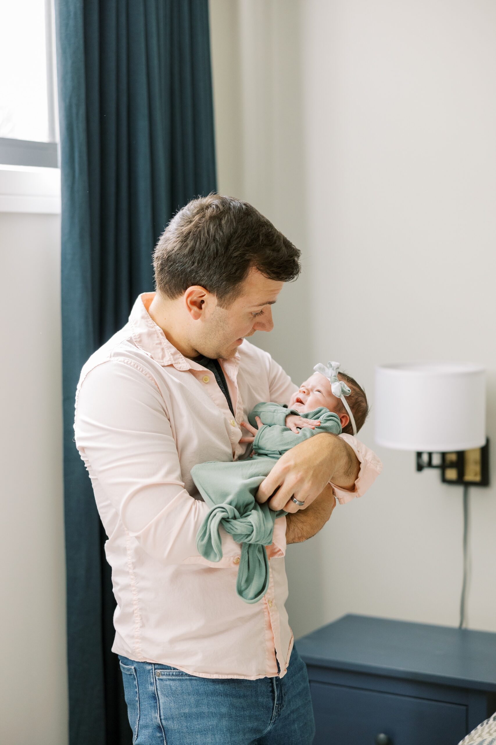 Dad holds newborn at intimate at home newborn session