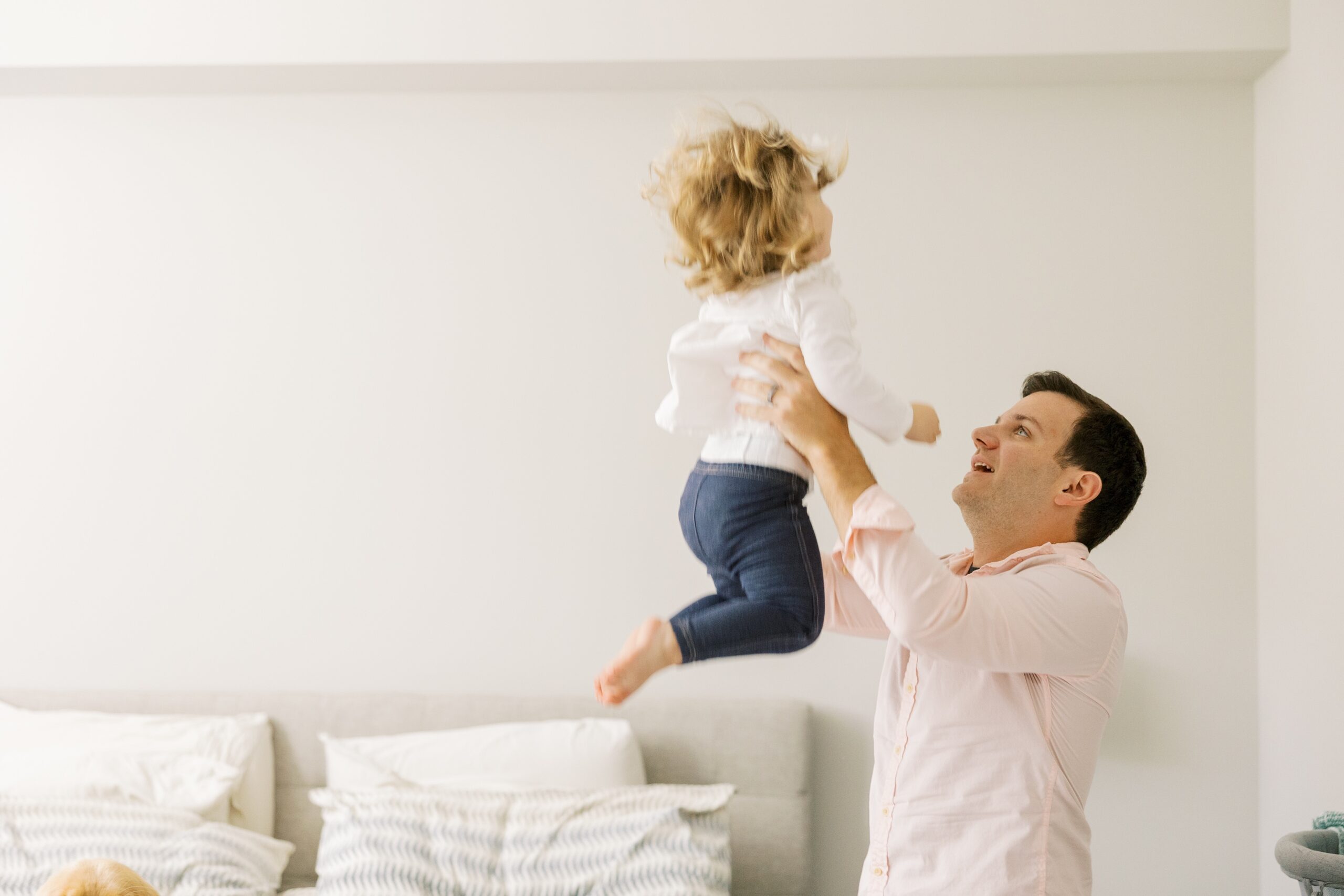 Dad plays with toddler during at home photo session