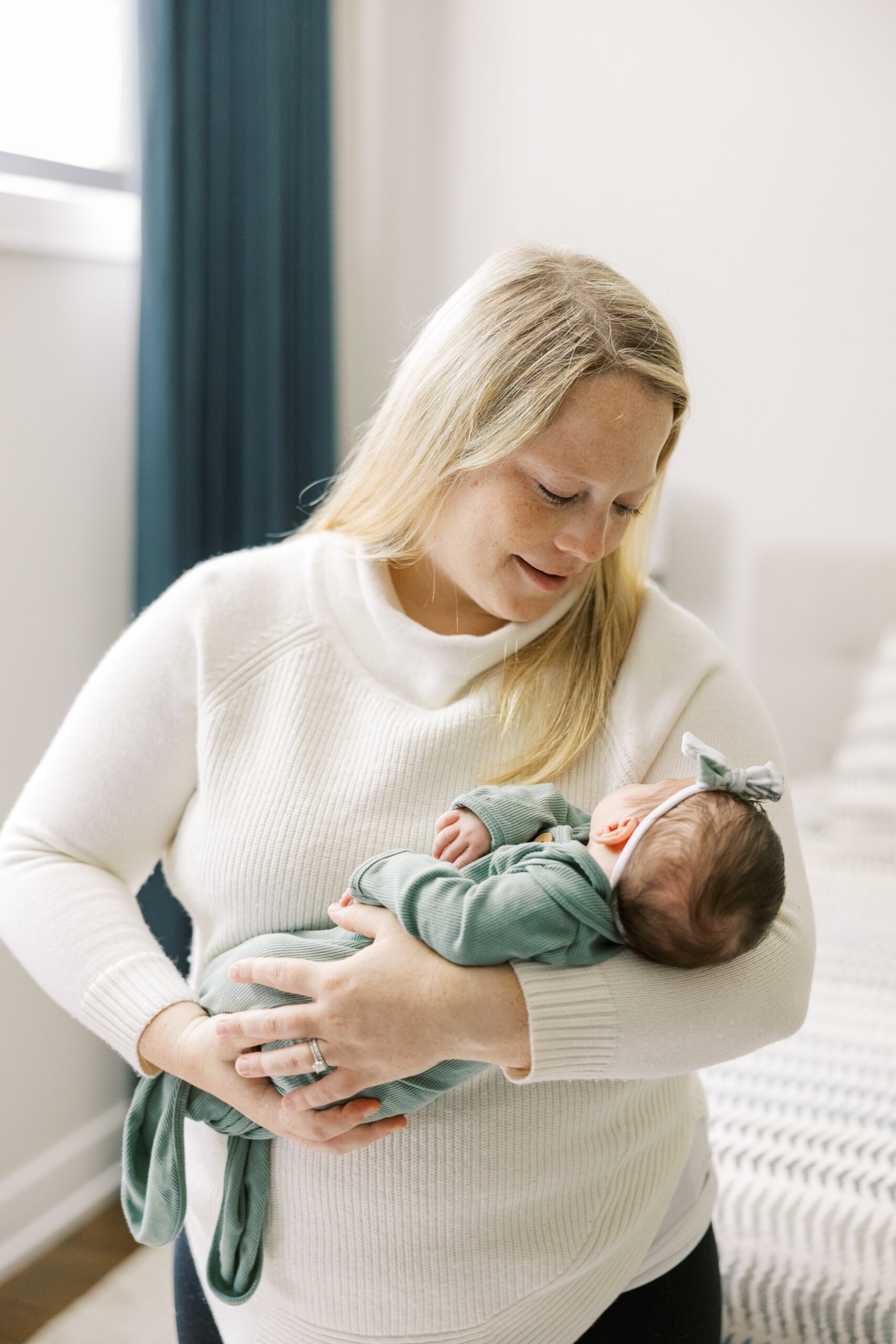 Mom holds newborn baby during intimate at home newborn session