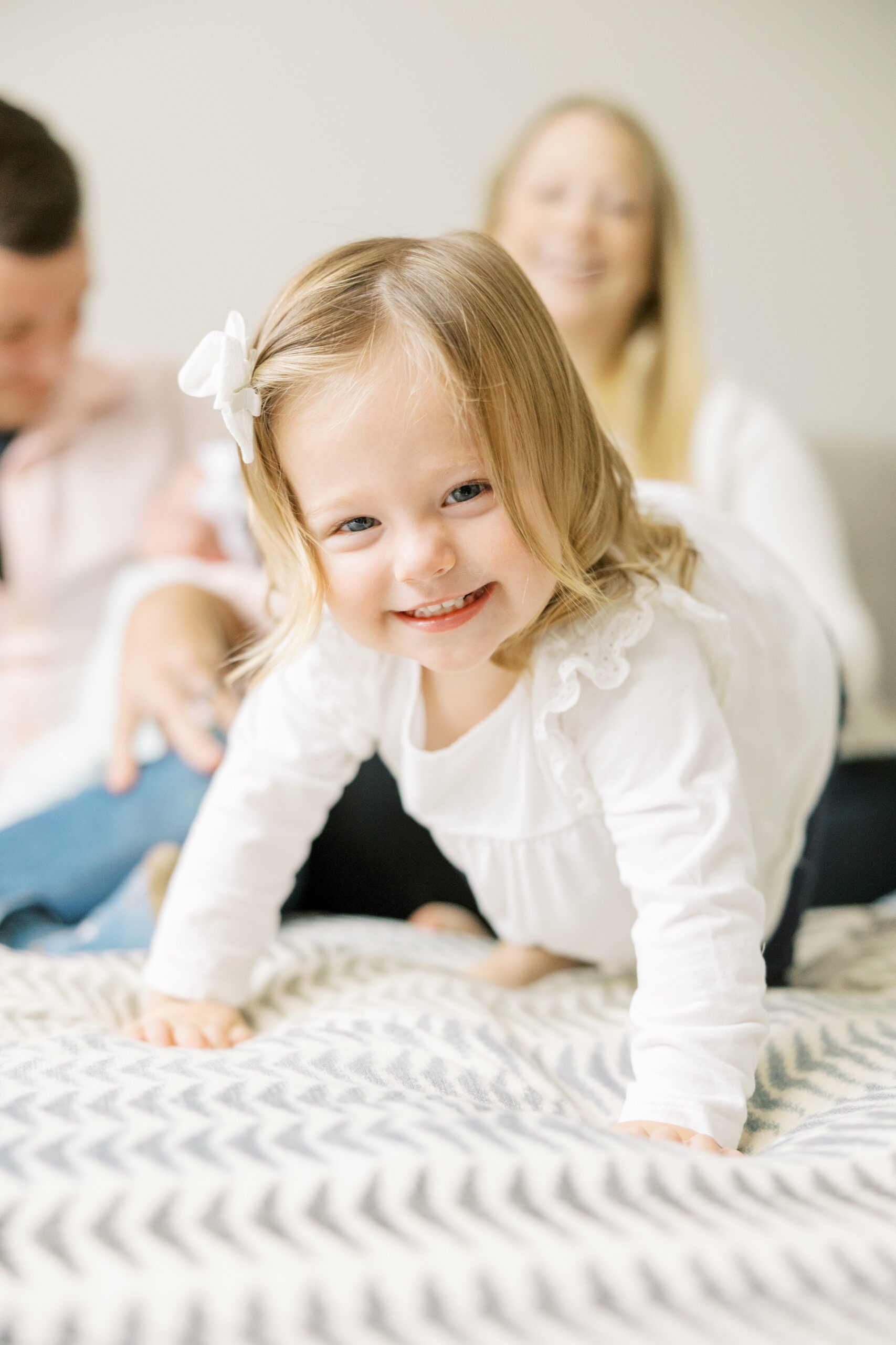 Toddler crawls towards the camera at intimate at home newborn session