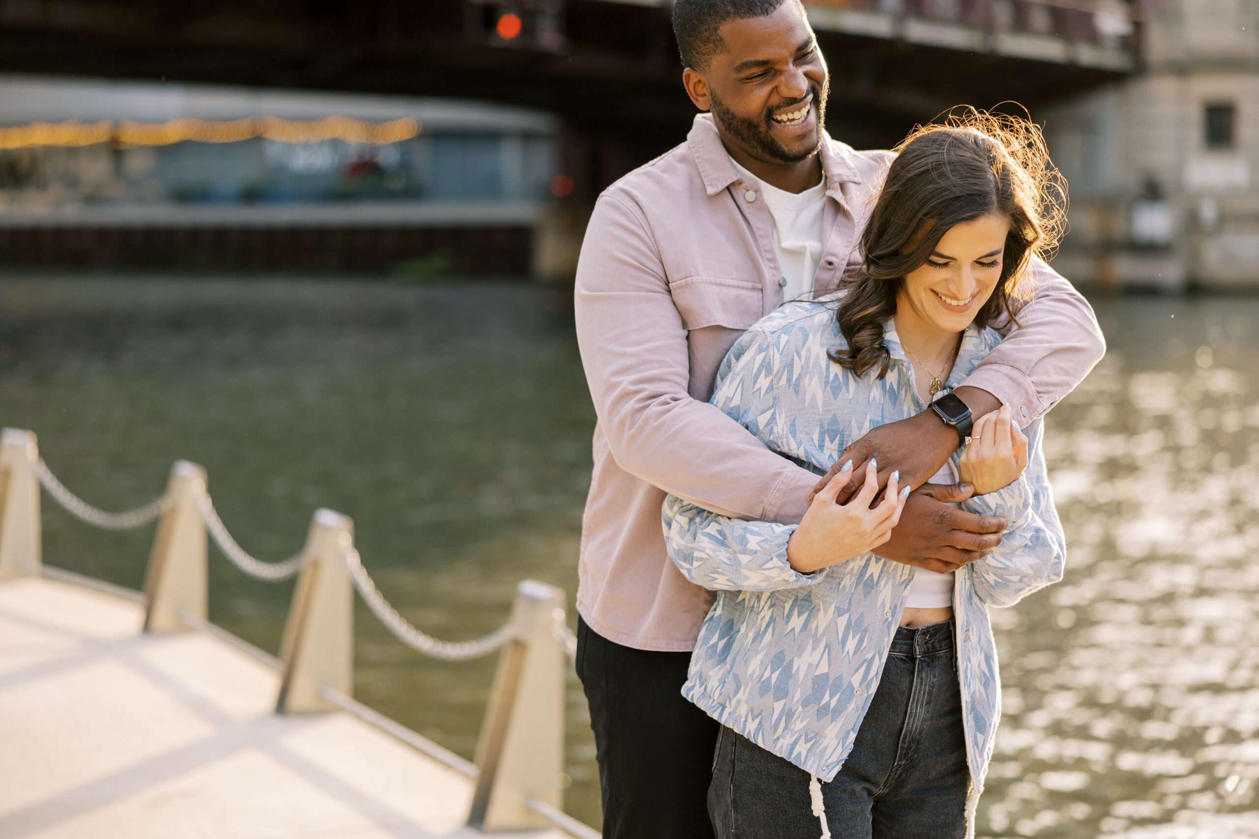 Man and woman hug playfully during sunset Downtown Chicago engagement session