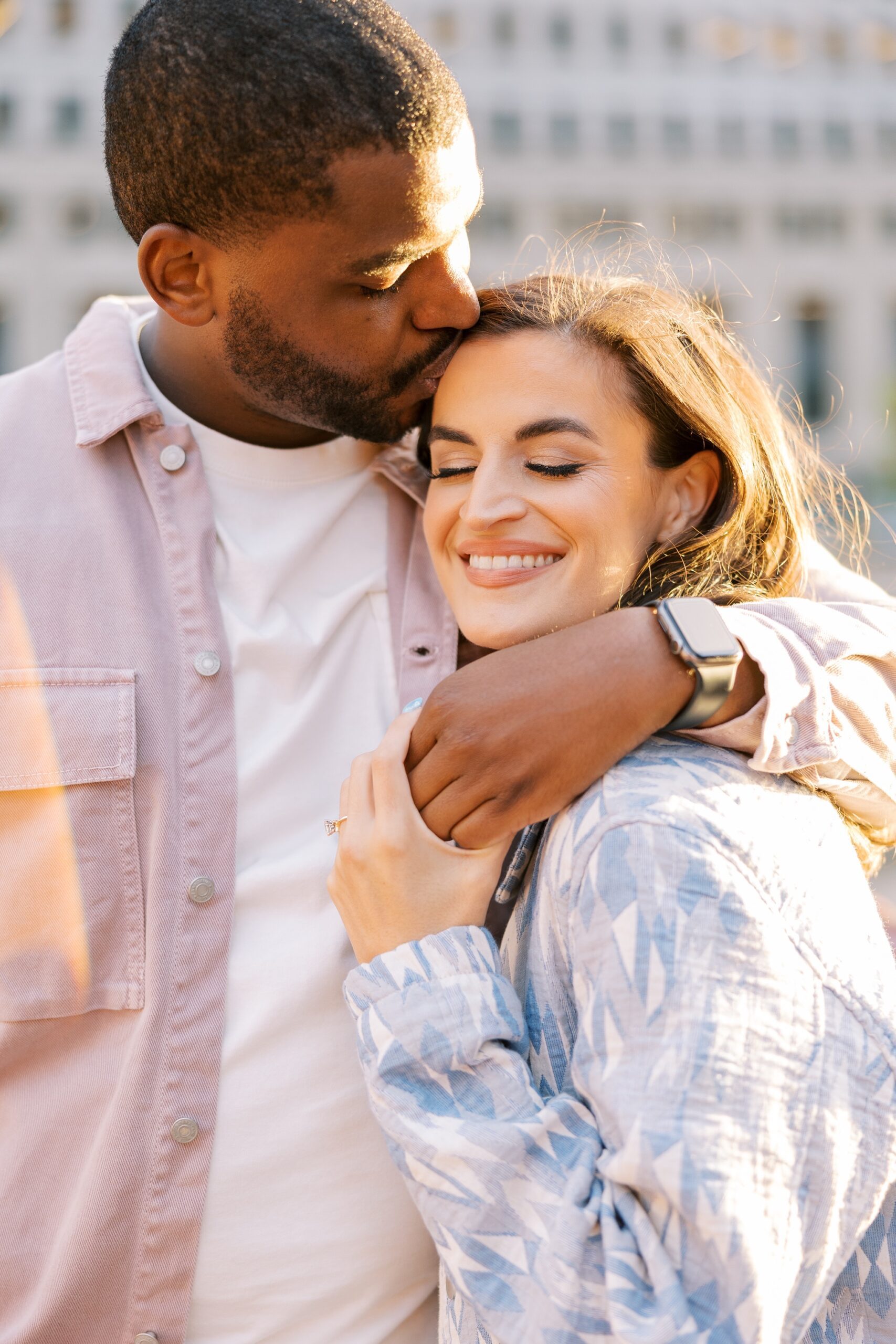 Man kisses woman on forehead during Chicago engagement pictures