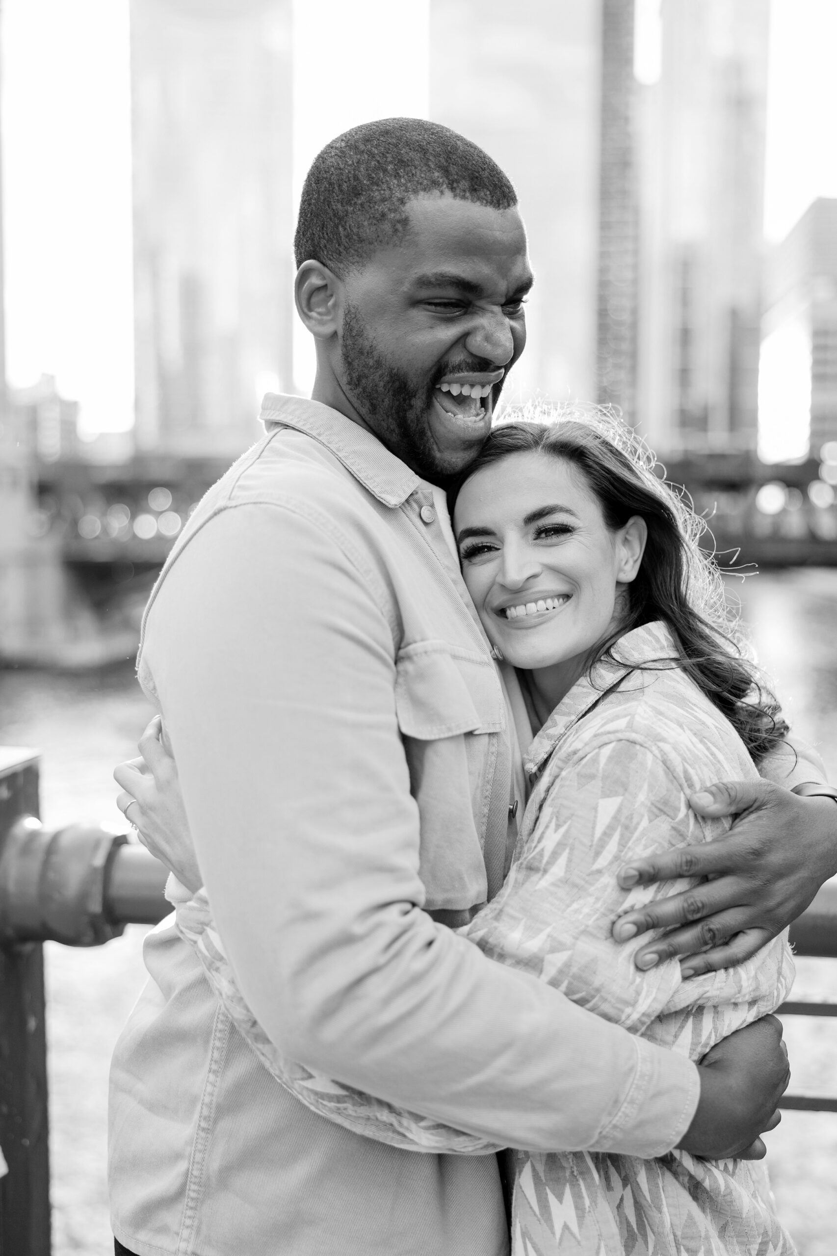 Man laughs and woman smiles during sunset engagement session in Chicago