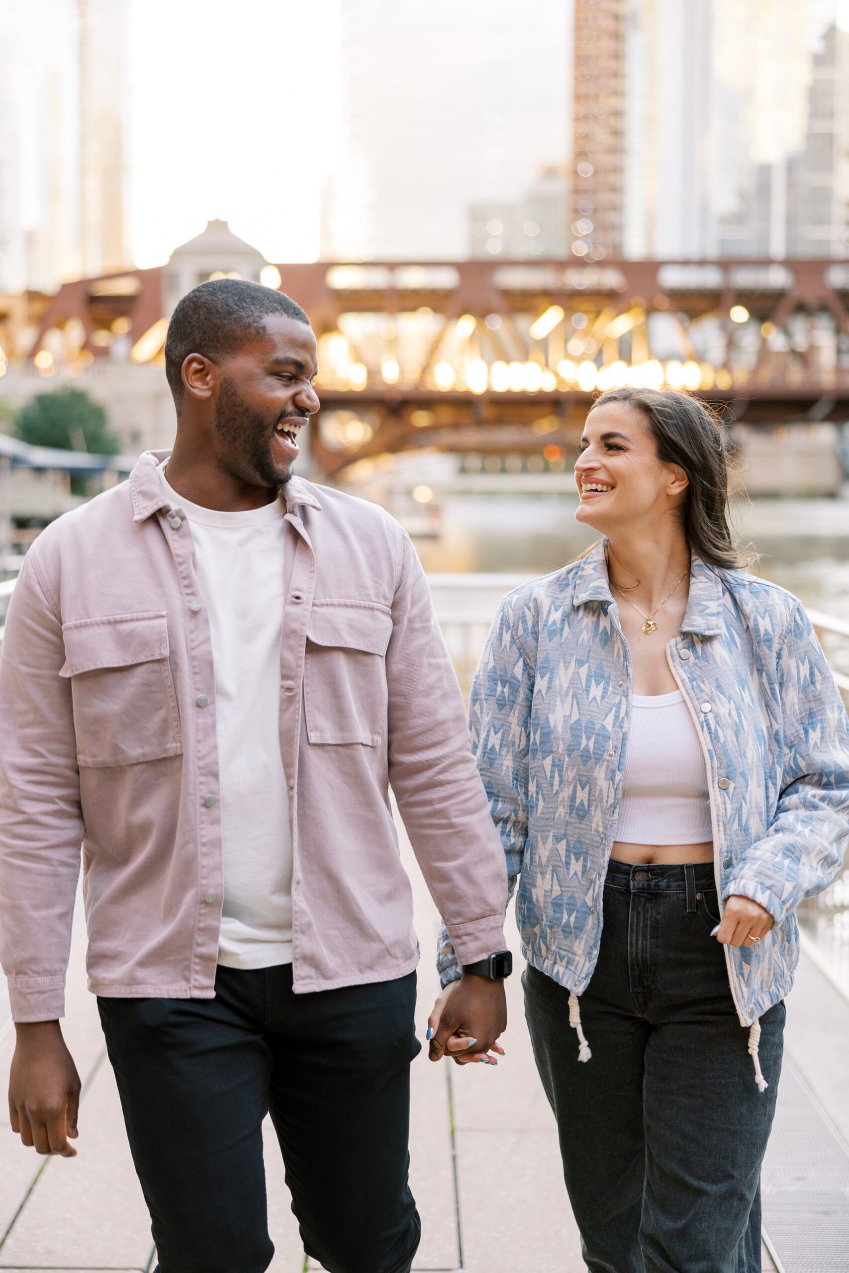 Man and woman smile at each other during sunset Downtown Chicago engagement photo session