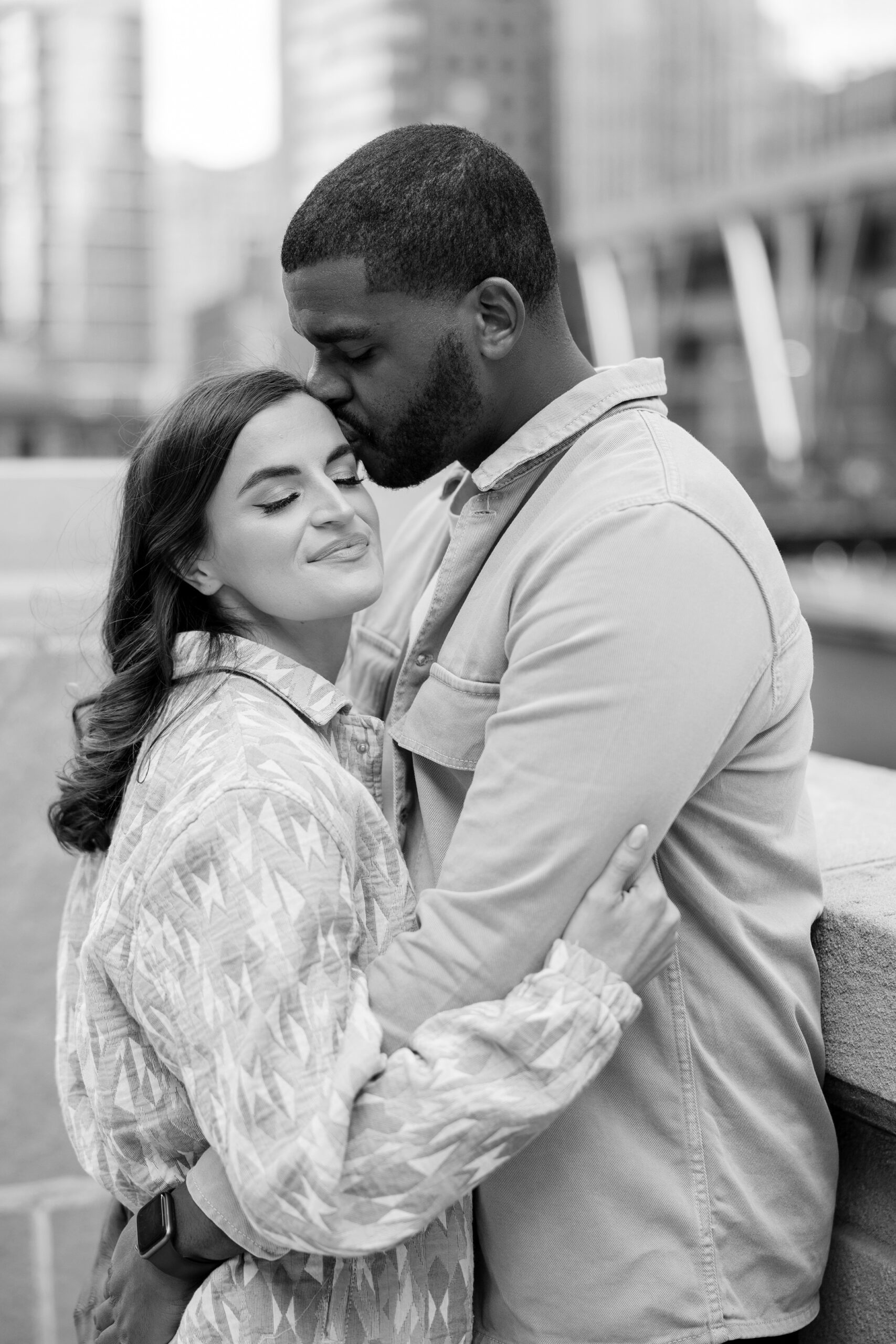 Man kisses woman on the forehead during Downtown Chicago engagement photos