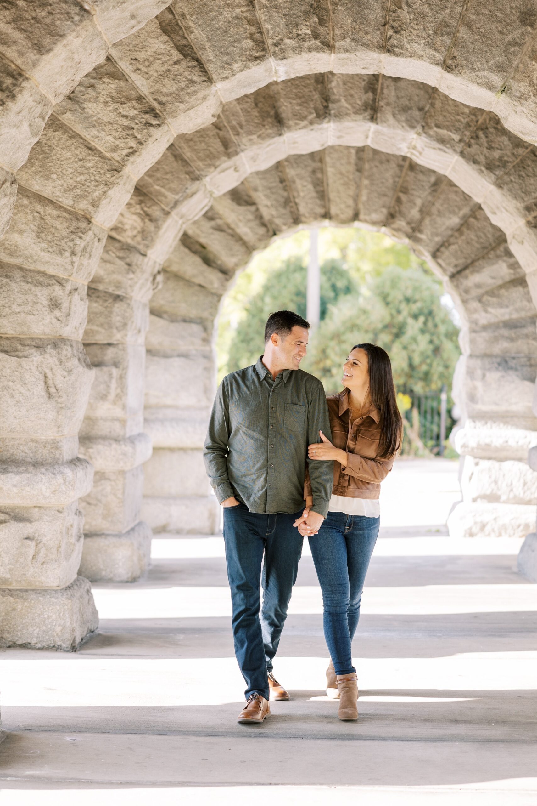 Couple walks hand in hand at fall Lincoln Park Zoo engagement