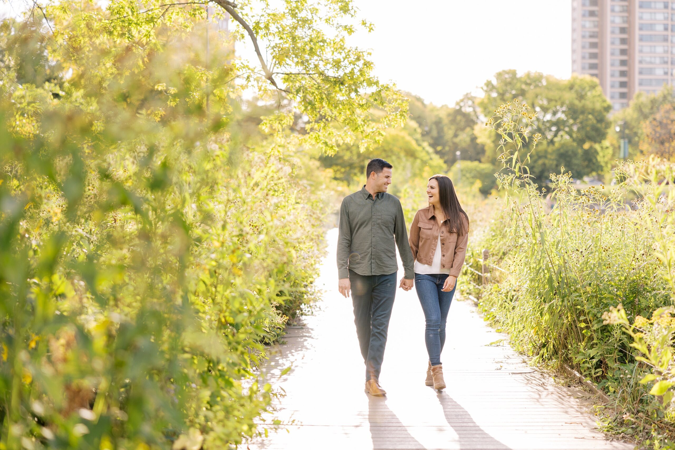Couple walks holding hands at Lincoln Park Zoo engagement photoshoot