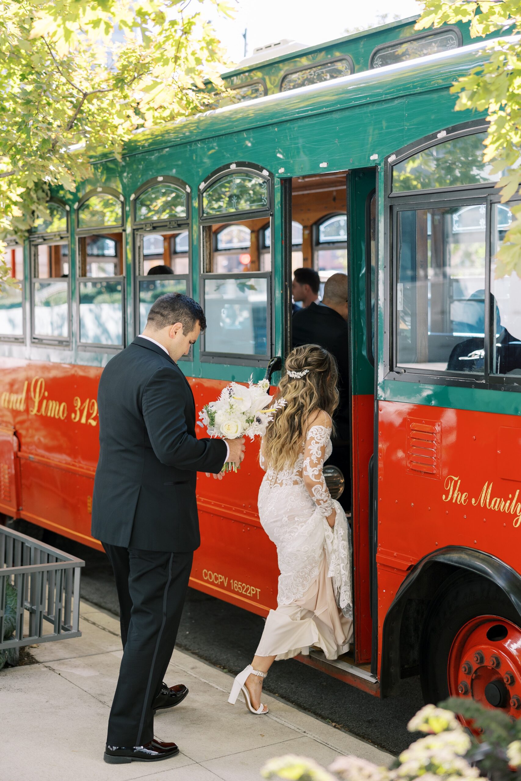 Bride and groom step onto trolley at Chicago wedding