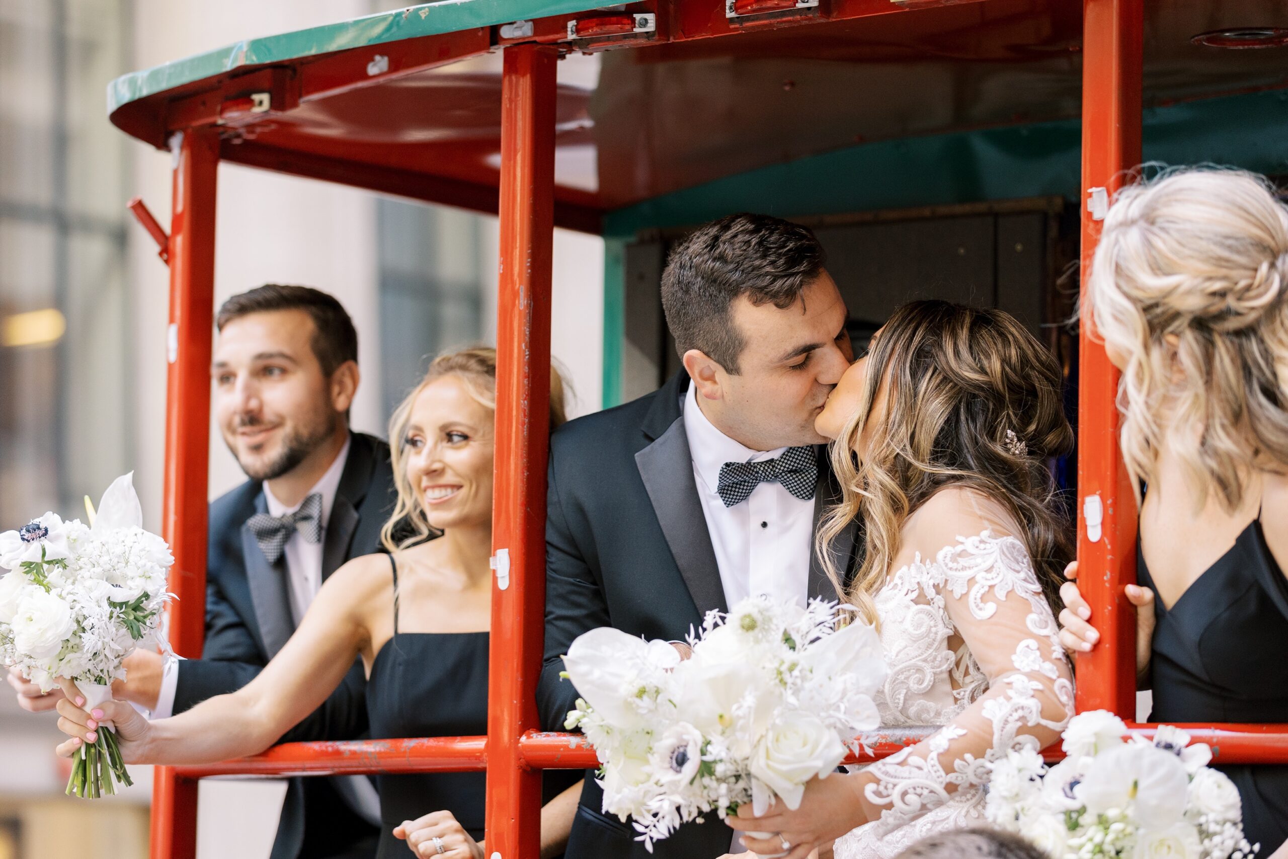 Bride and groom kiss on back of trolley in downtown Chicago