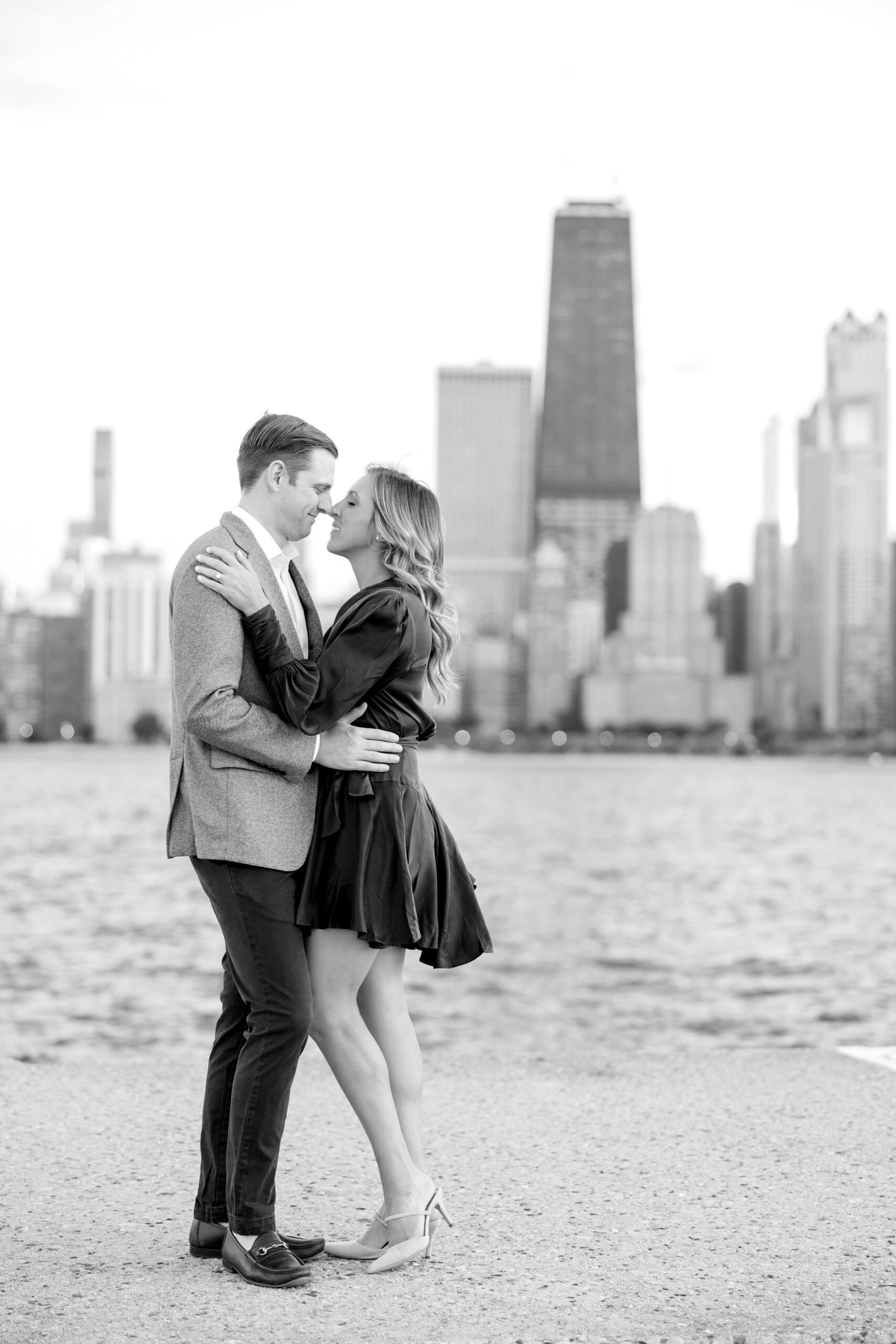 Couple hugs during fall engagement photos in Chicago at North Avenue Beach