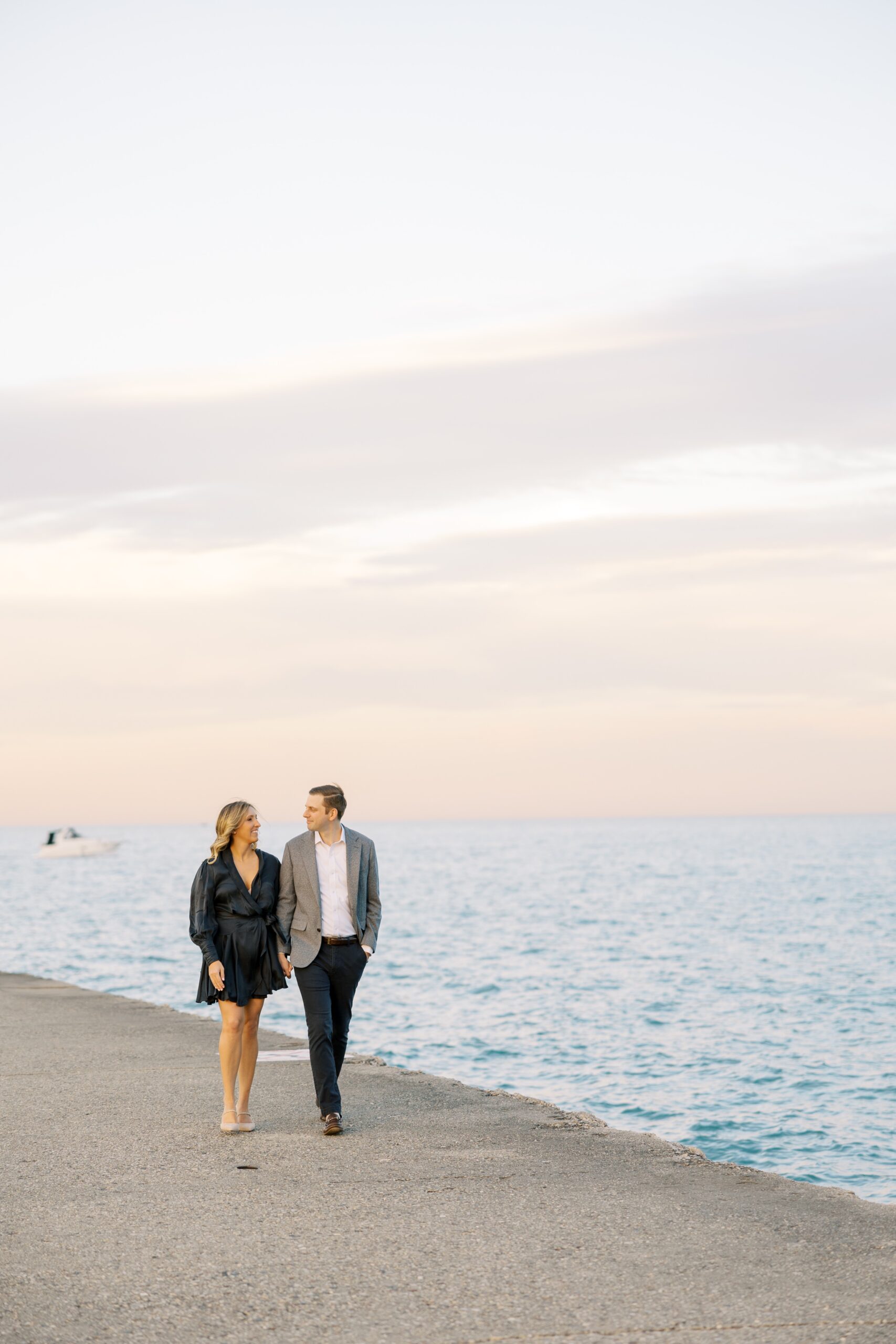 Man and woman hold hands during fall North Avenue Beach engagement photos