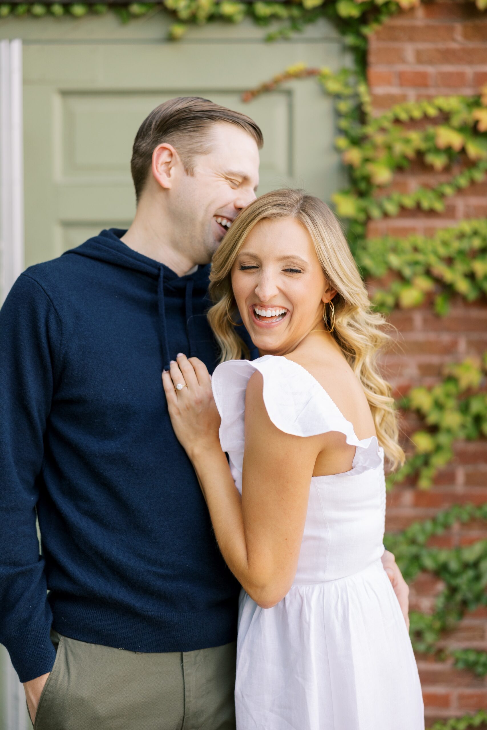 Man and woman laugh during engagement photos session