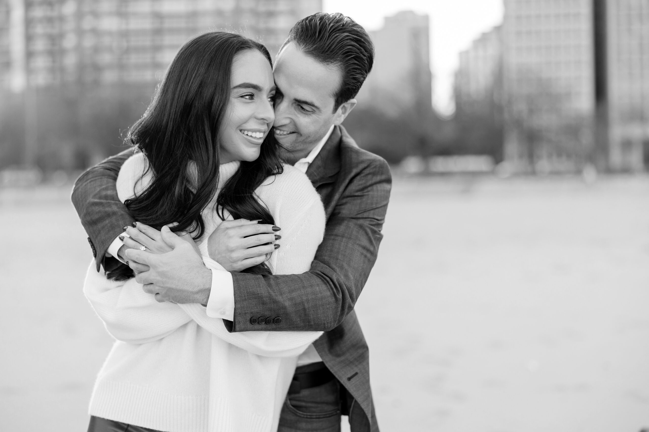 Man hugs woman from behind during Chicago engagement session
