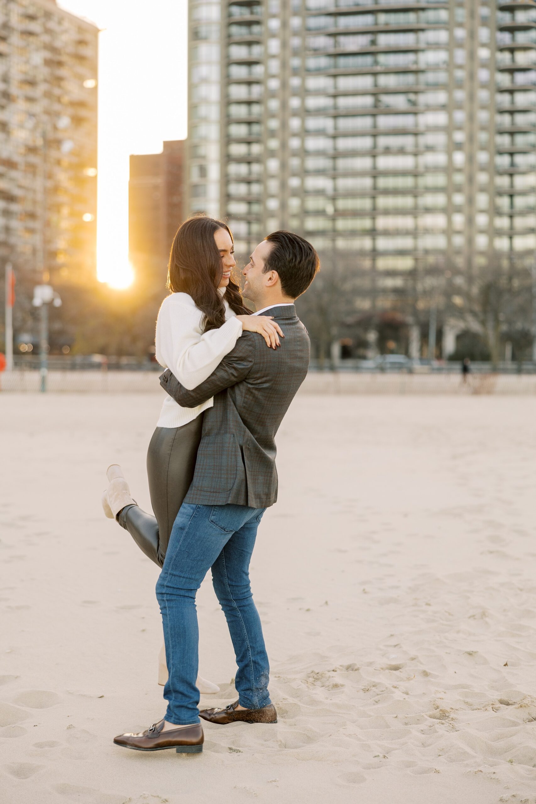 Man picks up woman and spins during downtown Chicago engagement photos