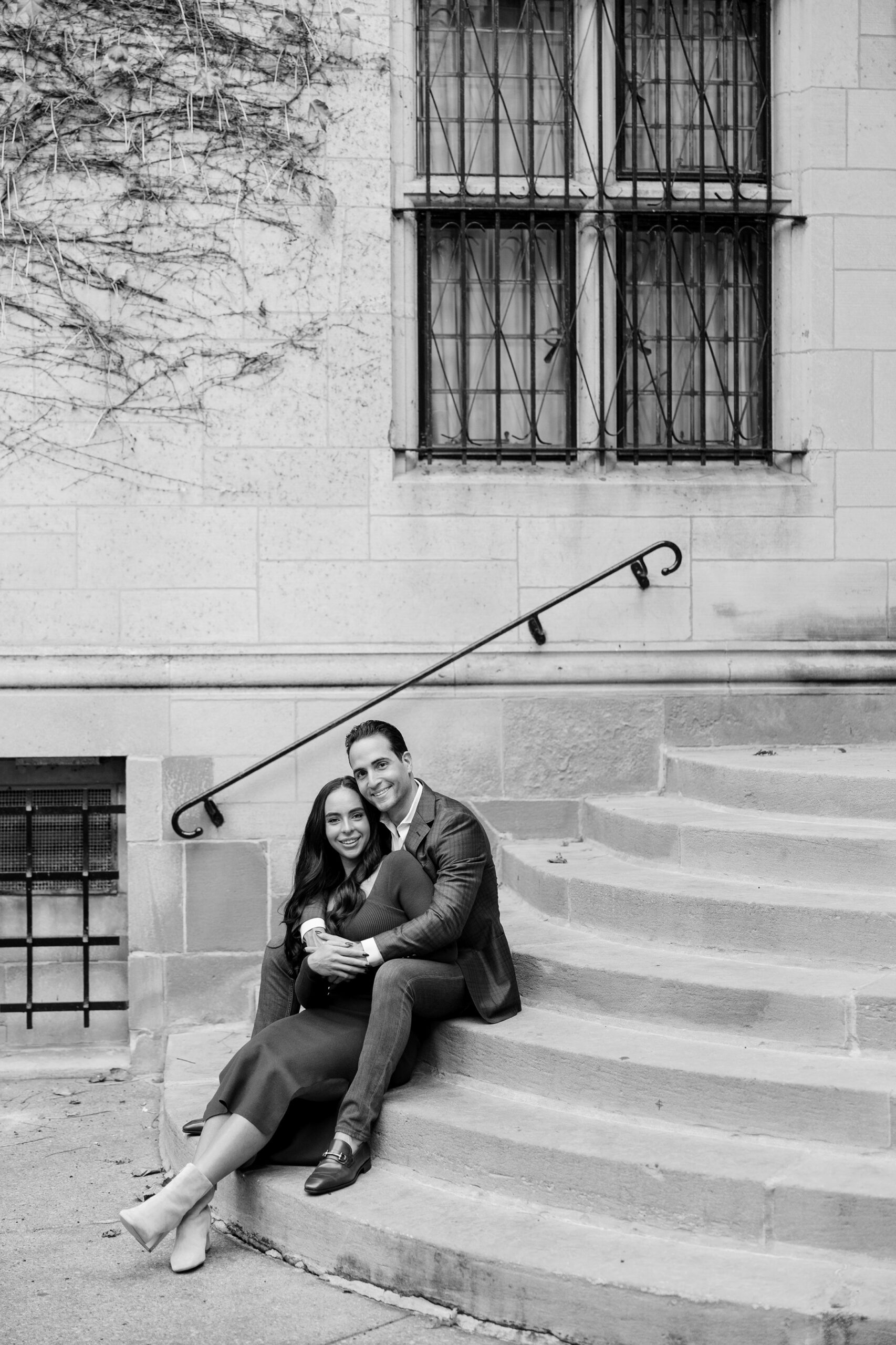 Man and woman sit on stairs at Fourth Presbyterian Church engagement session