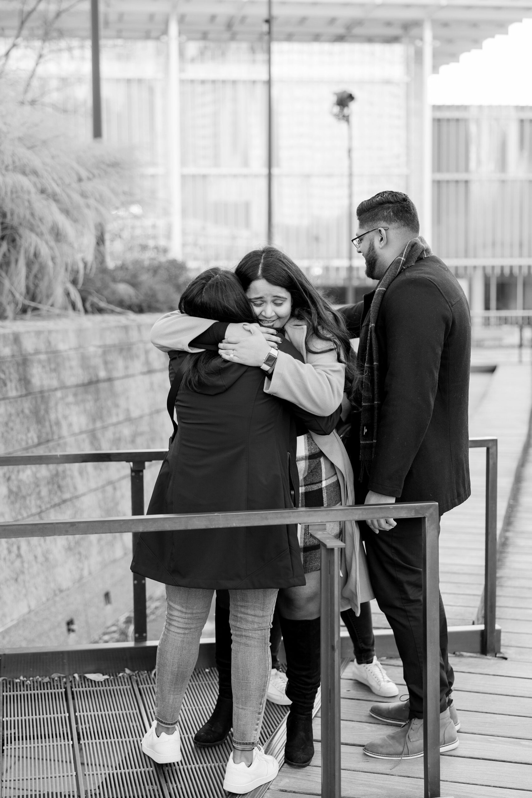 Man and woman hug friends after their proposal