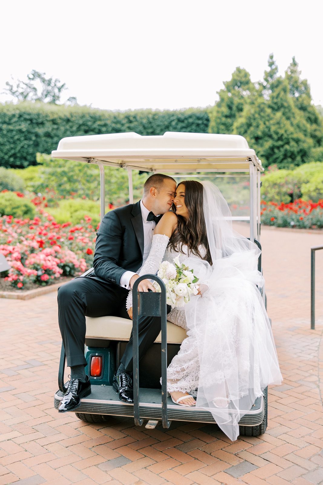 Bride and groom ride on golf cart at their Chicago Botanic Garden wedding