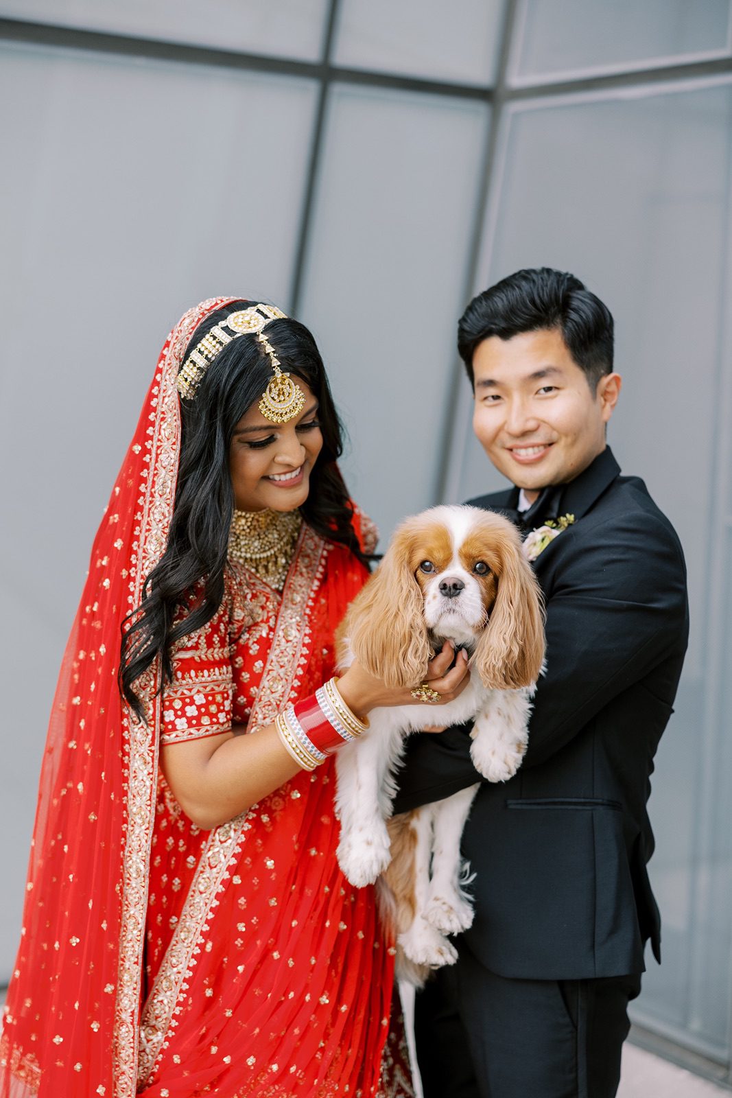 Bride and groom pose with their dog before their wedding ceremony