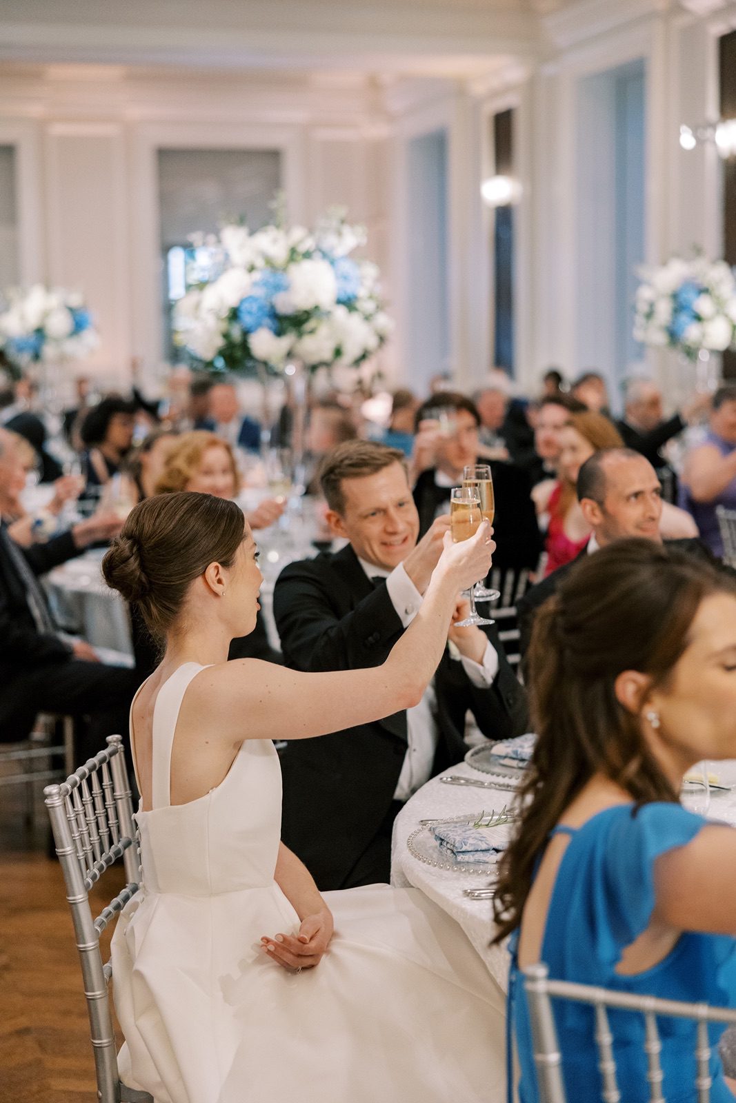 Bride and groom toast at their Chicago History Museum wedding reception